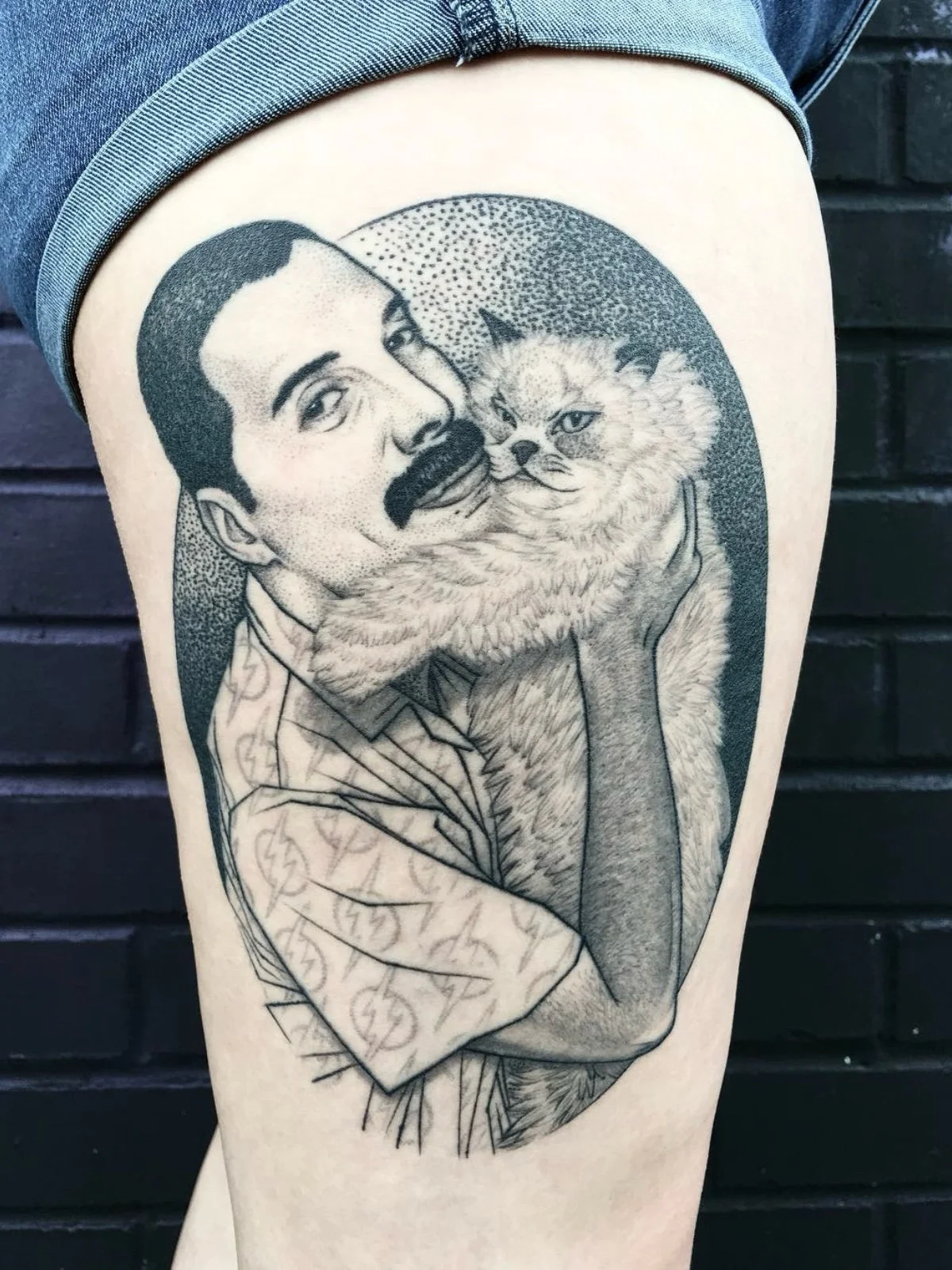 Healed dotwork, fine line, and black and grey celebrity tattoo portrait of Freddie Mercury holding his fluffy cat, created by Seattle tattoo artist Eli Bischof.