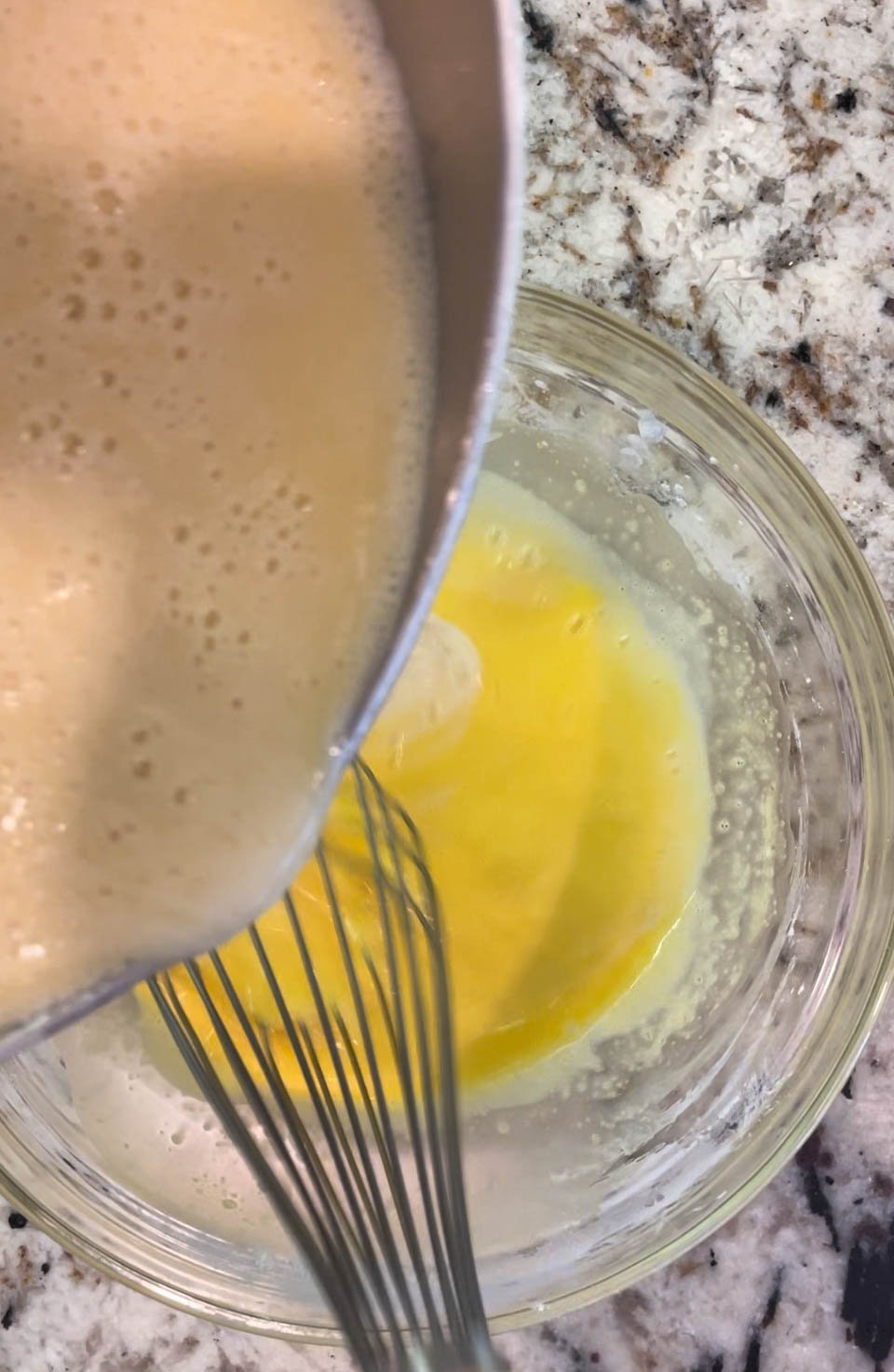 Add half the milk mixture into the eggs, whisk consistently.