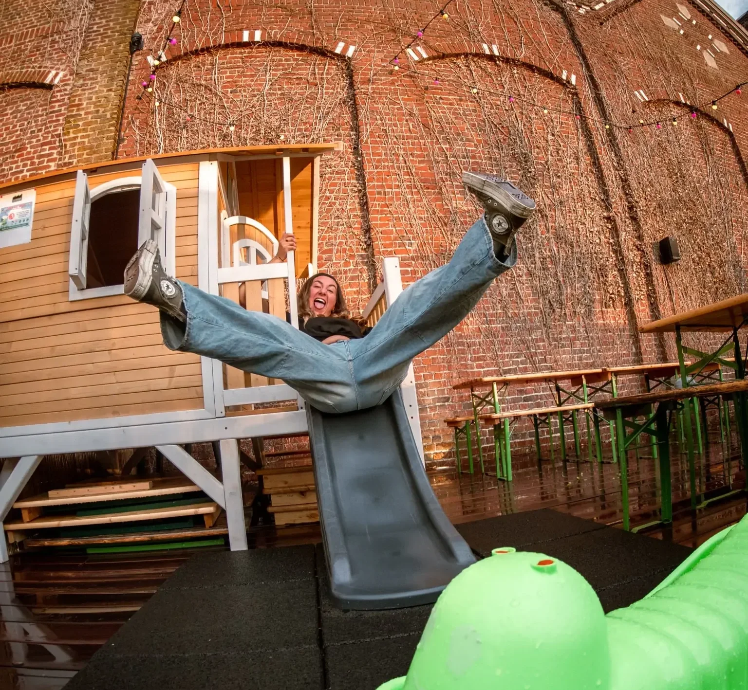 Une femme qui descend sur le toboggan de l'aire de jeux de la Friche Gourmande Saint-André-lez-Lille