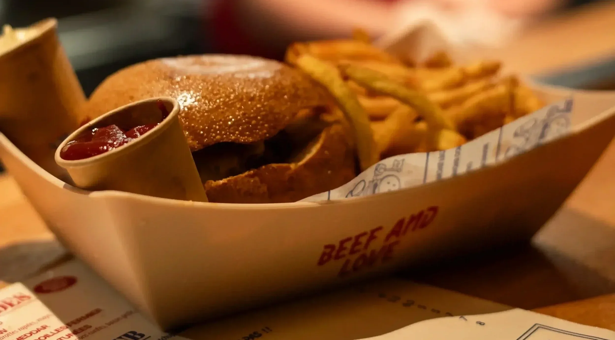 Un gros burger et ses frites posé sur le comptoir du Comptoir Volant