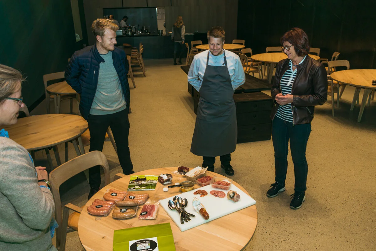 Smaksprøver. Fem lokalmatprodusenter har tatt steget under vann denne dagen: Kviljo økologiske gård ved Ragnhild Senum, Penne økologiske hage ved Wenche Ellingsen, Vintlands Bringebær ved Anne Vintland, Heddan Gard ved Ellen Rebekka Stokkeland og Enli Vestheim ved Ruth Elisabeth Mikalsen (til høyre). – Jeg håper han kunne tenke seg å ta inn et produkt som vi kunne brukt til en av forrettene. Det hadde vært veldig gøy, sier Mikalsen, som her viser frem kjøttprodukter foredlet på Lista.