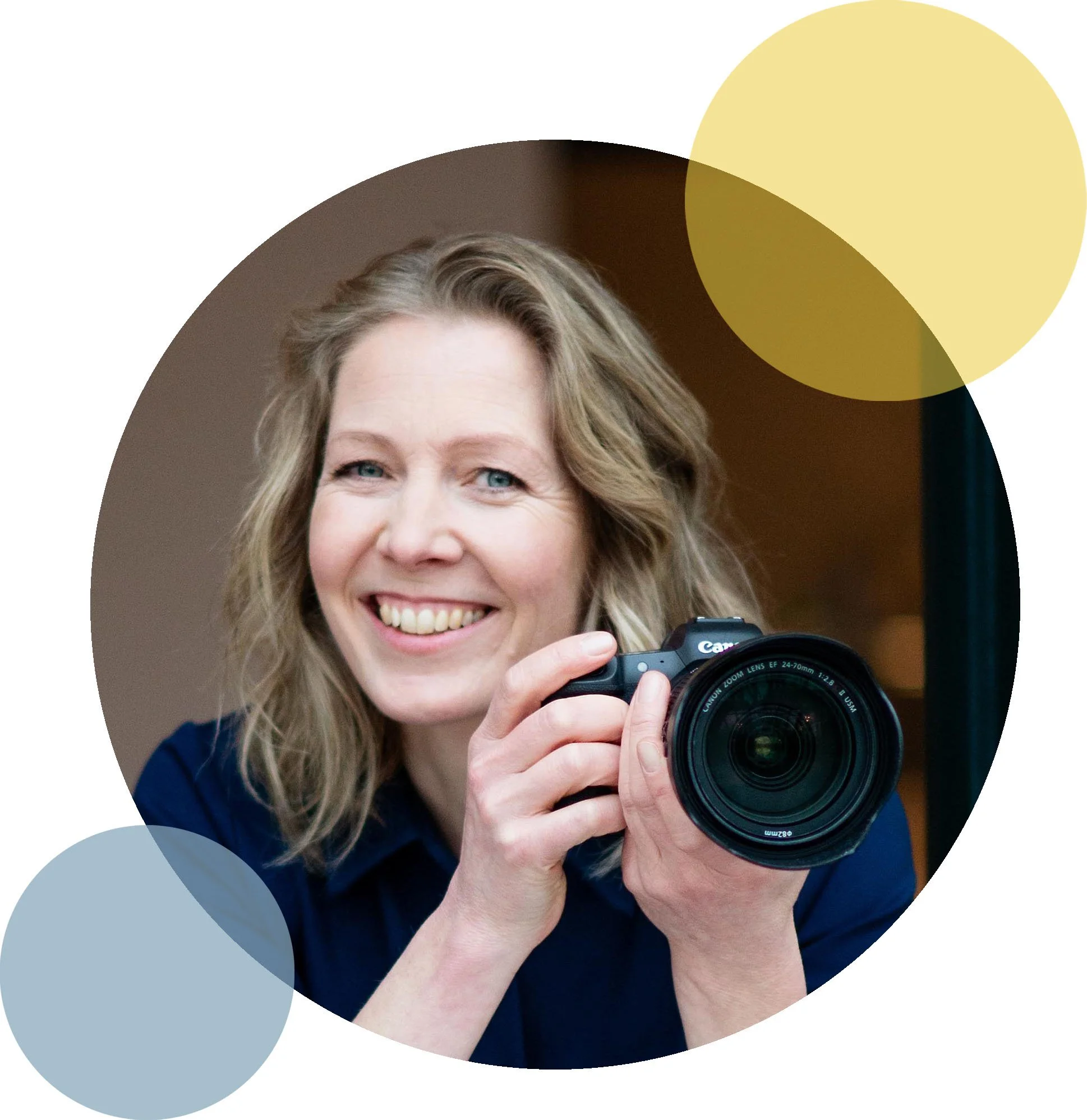 Een lachende vrouw die een digitale camera vasthoudt, in een interieur met een neutrale achtergrond.