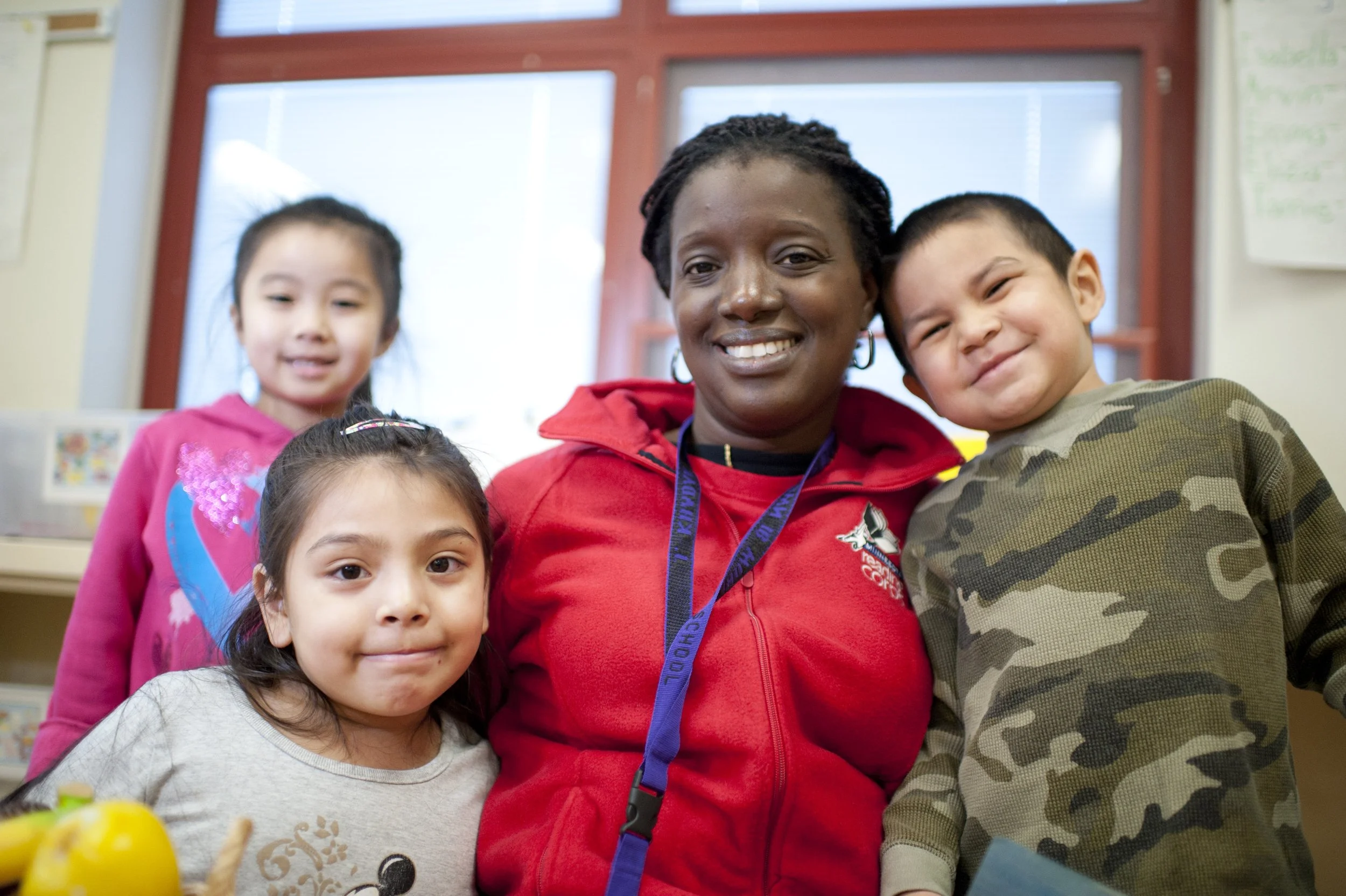 Reading tutor poses with students