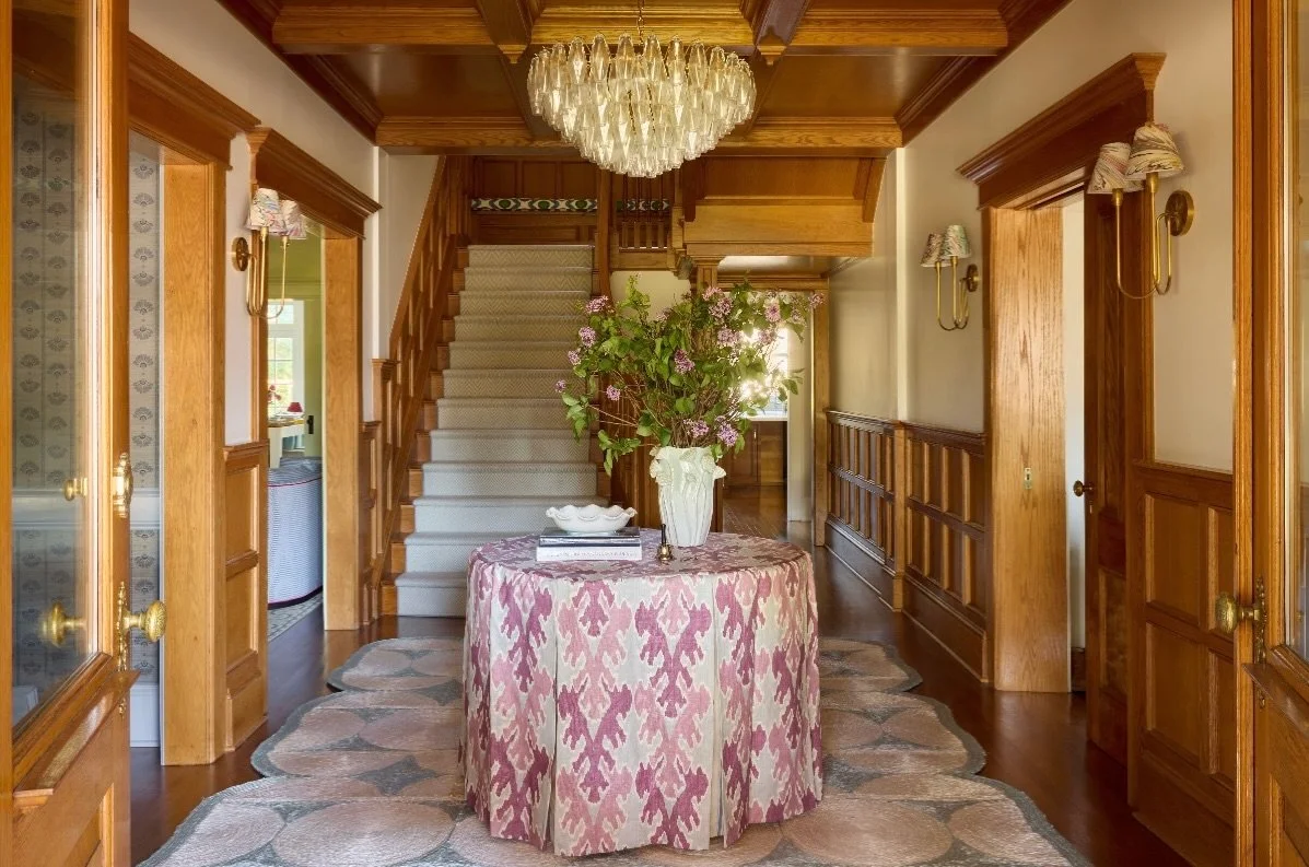Why mess with a good thing?

The original woodwork in this gracious foyer was a keeper. We left it untouched and introduced our signature layers of color and pattern. A custom scalloped sisal rug, a generously skirted table in a punchy pink, playful 