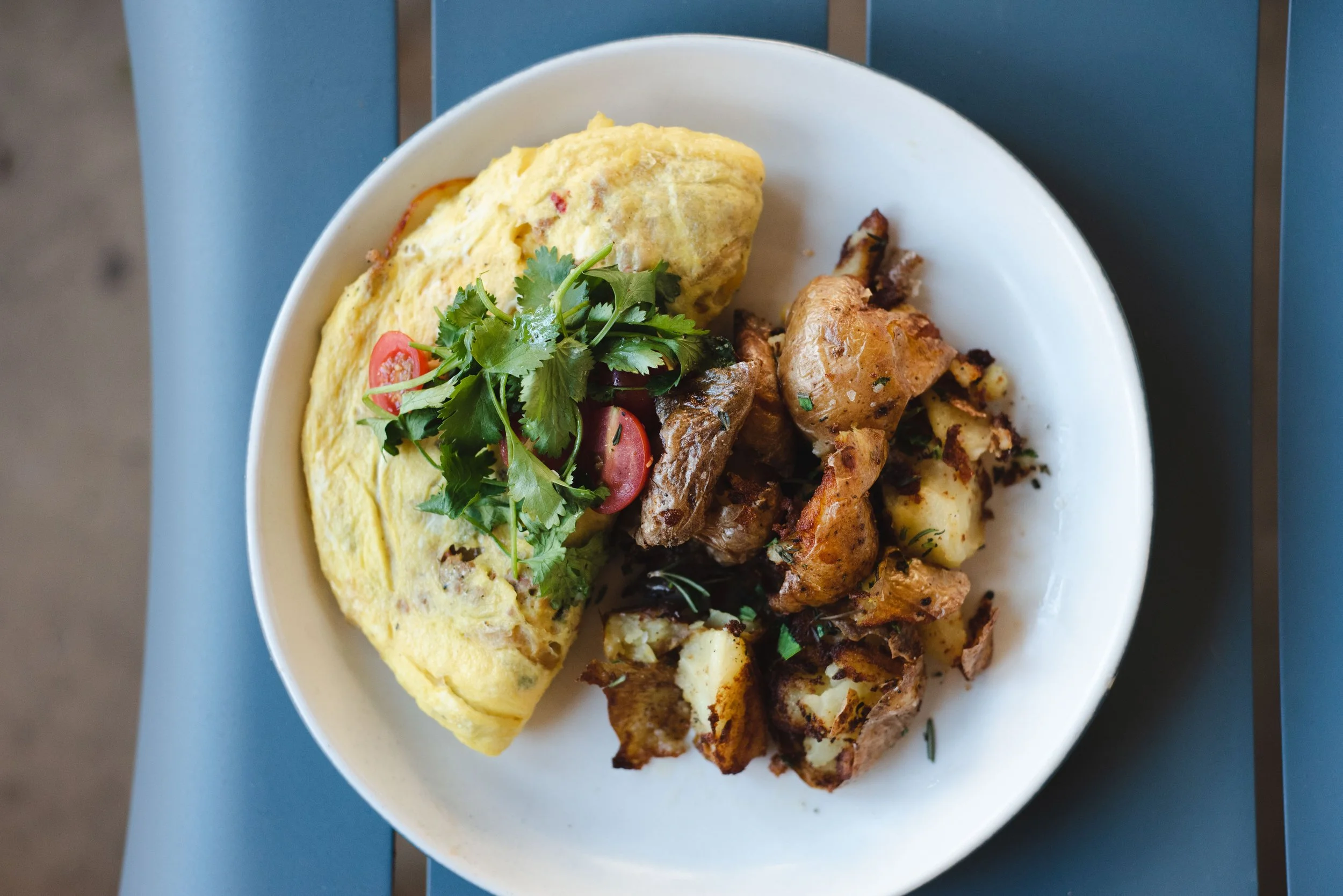 A roasted vegetable and sweet potato hash bowl topped with a fried egg and fresh greens, as served at Prep & Pastry Scottsdale..jpg