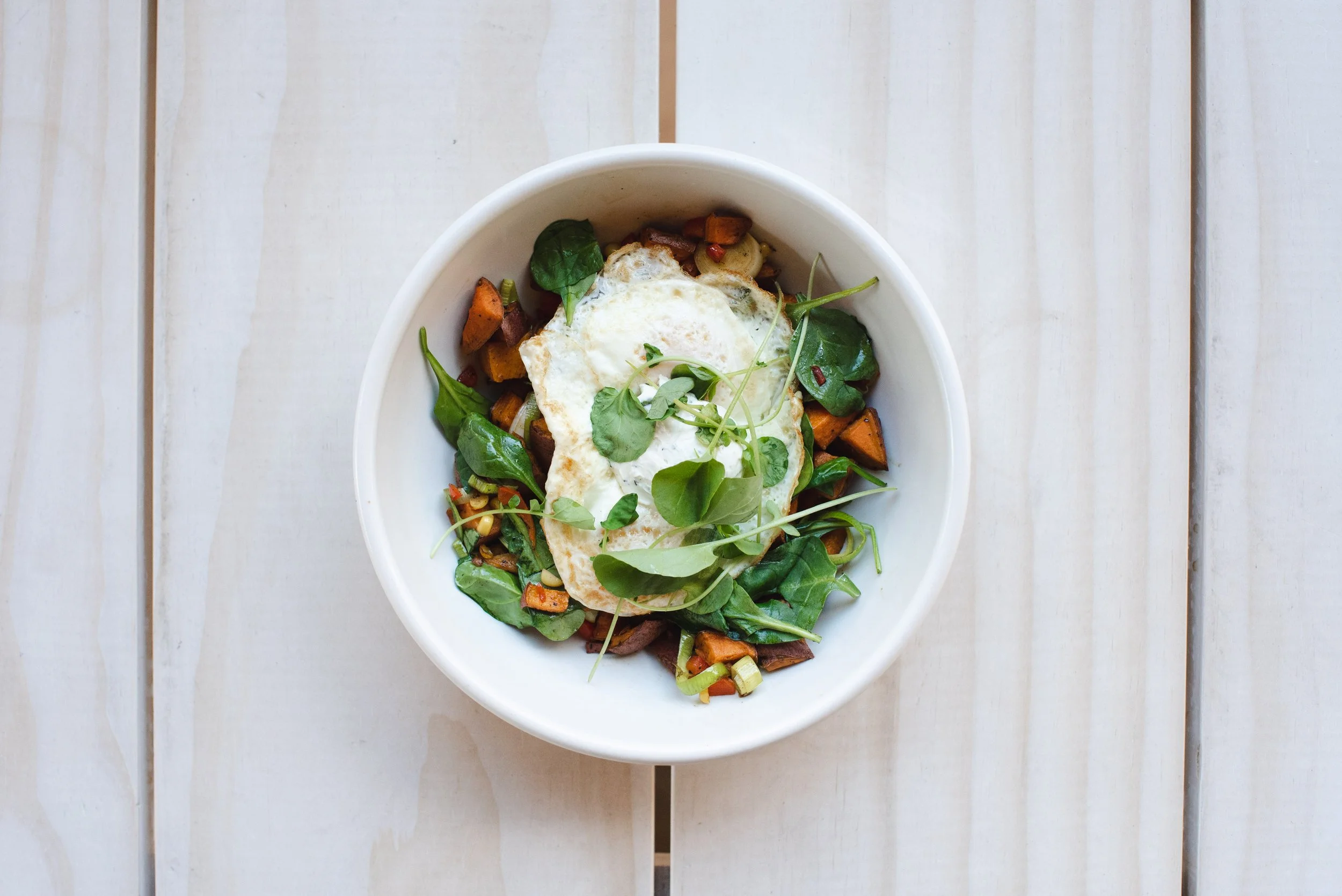 Shakshuka served in a rustic cast-iron skillet, featuring poached eggs in a savory tomato sauce with fresh herbs and toasted baguette slices..jpg