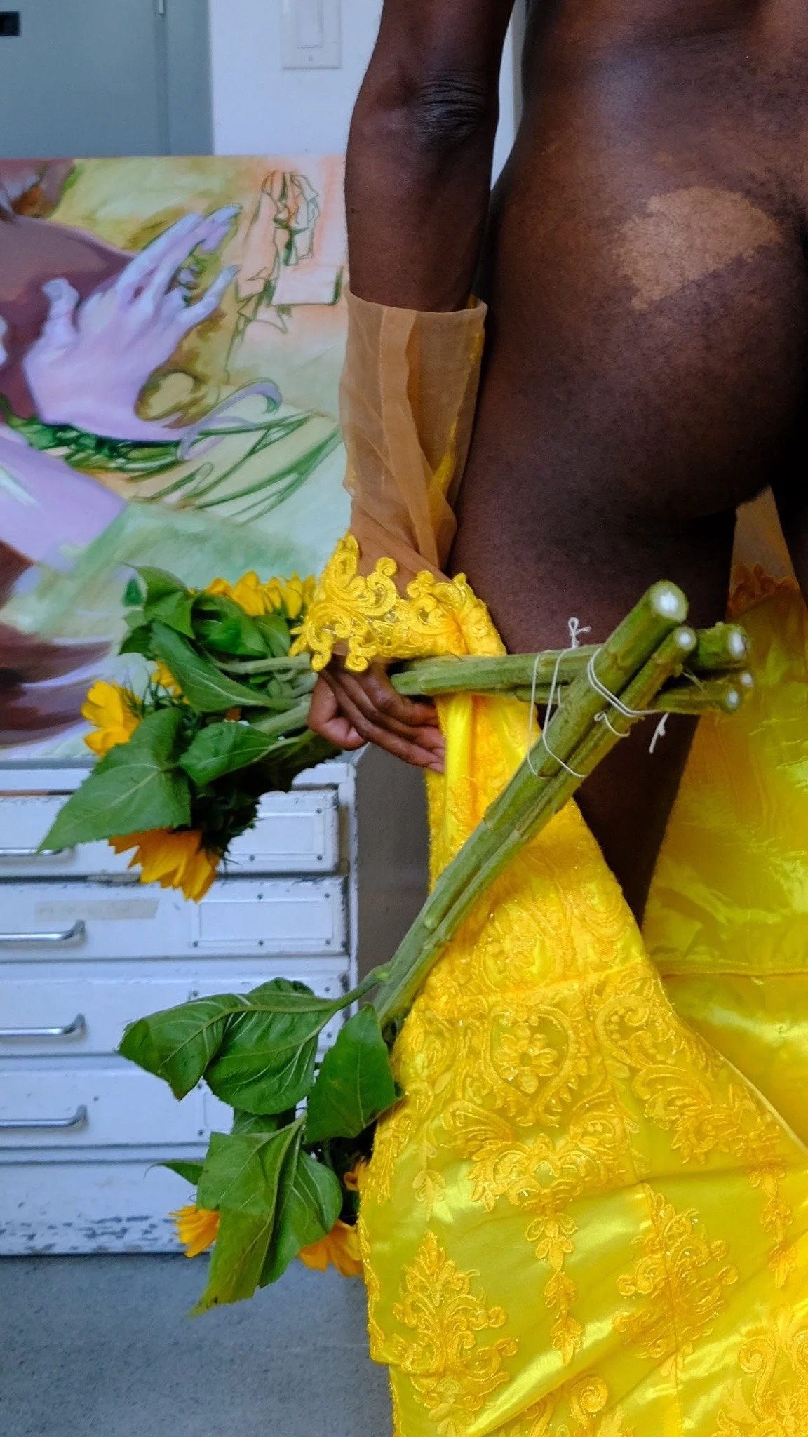 Details in the floral yellow dress. Potentially getting a bouquet or floral prop of some sort.