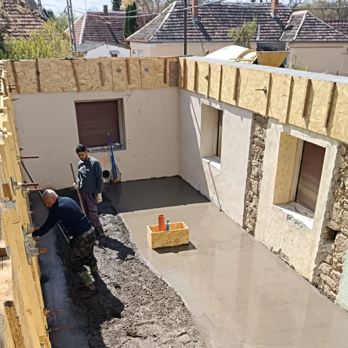 Spotkanie inwestora z architektem przy kawie – omawianie projektu domu na podstawie szkiców, rzutów architektonicznych i analiz. Laptop, odręczne rysunki i stemple projektowe tworzą atmosferę profesjonalnych konsultacji nad koncepcją budynku