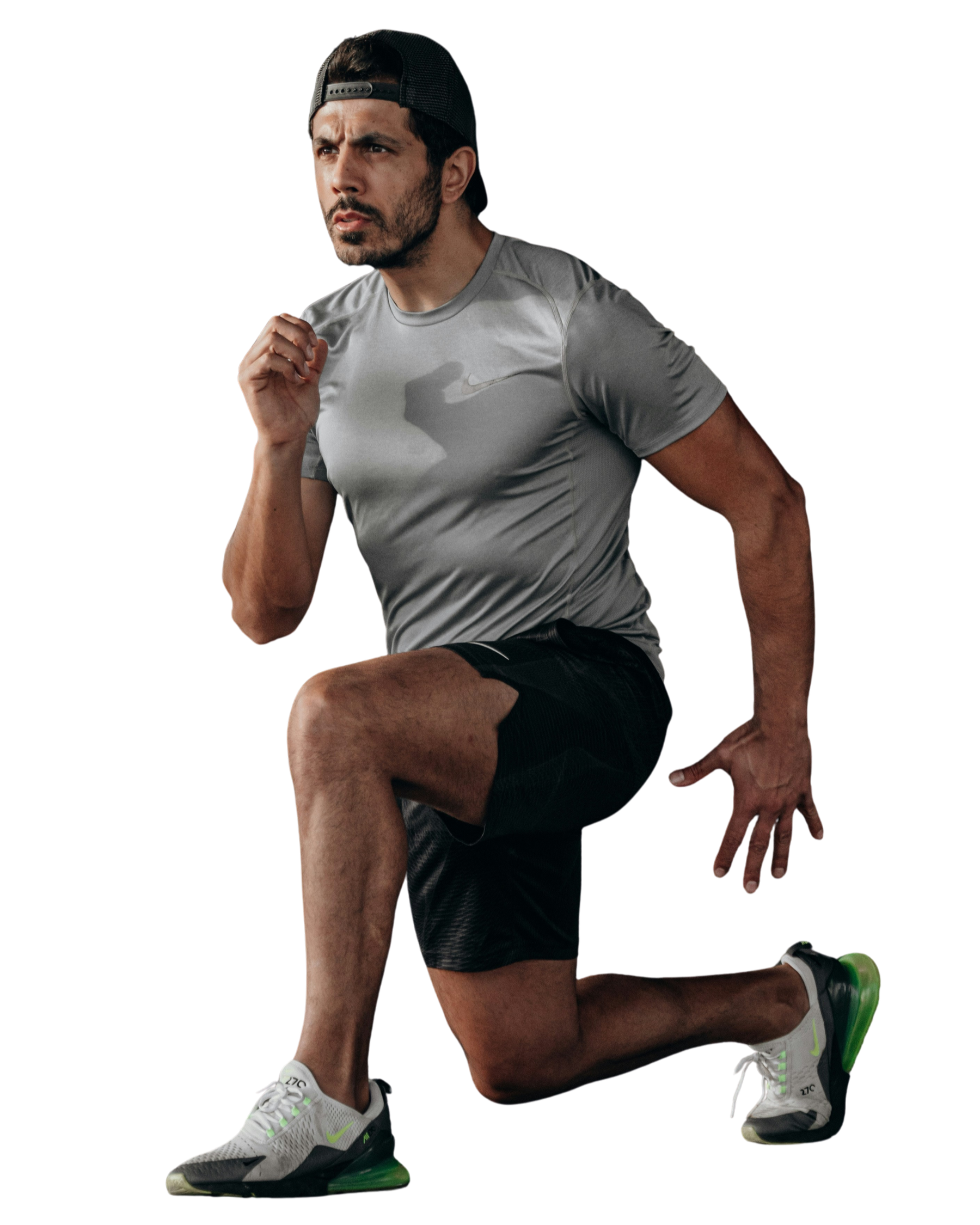 A man wearing a gray athletic shirt, black shorts, and gray running shoes with green accents, performs a stretching exercise on one knee while holding a position on a black background.