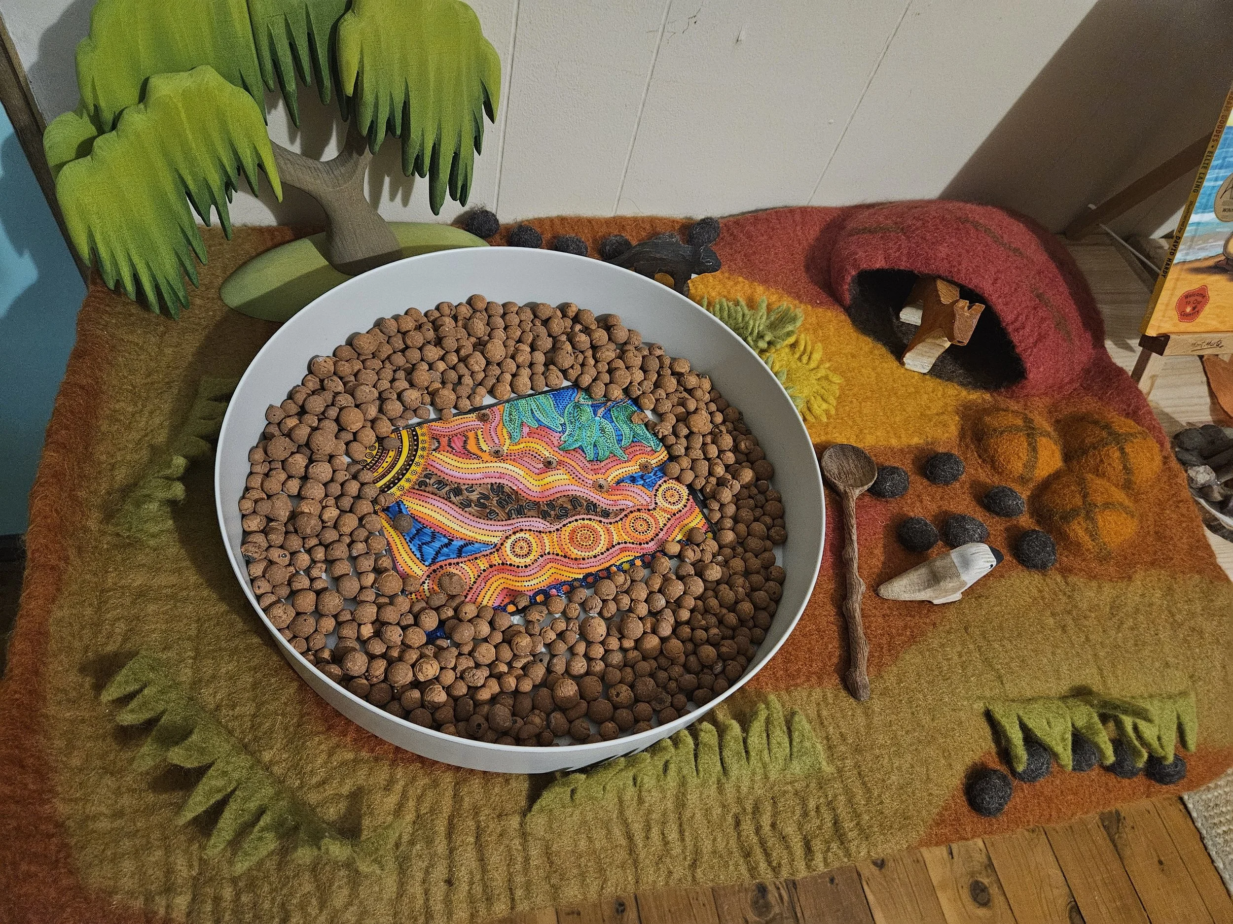 NAIDOC Week sensory play invitation featuring earthy sensory base colours, Australian animal figurines and open-ended learning materials.