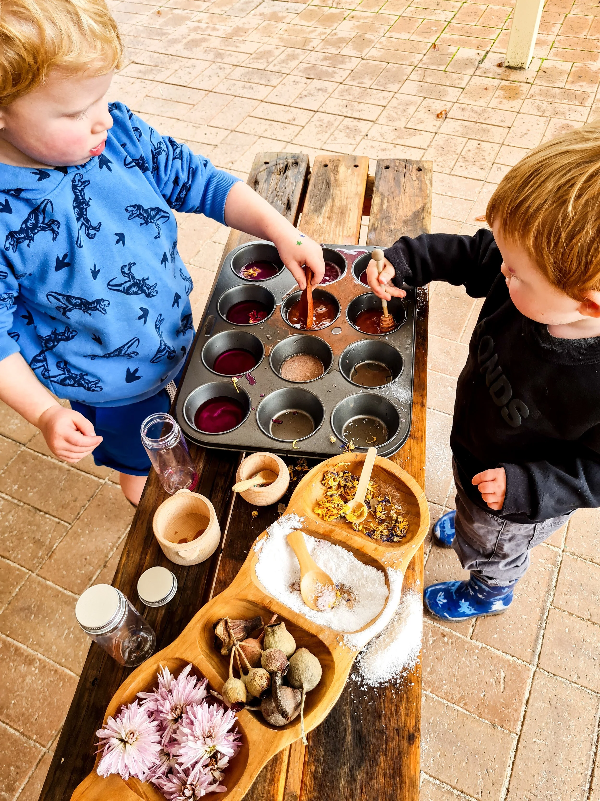 Children mixing fizzing potions with natural materials in a NAIDOC Week inspired activity that encourages curiosity and creativity.