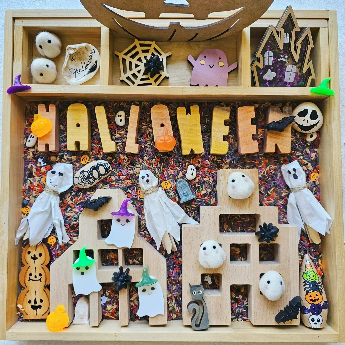 Halloween sensory play tray filled with loose parts, pumpkins and spooky themed treasures