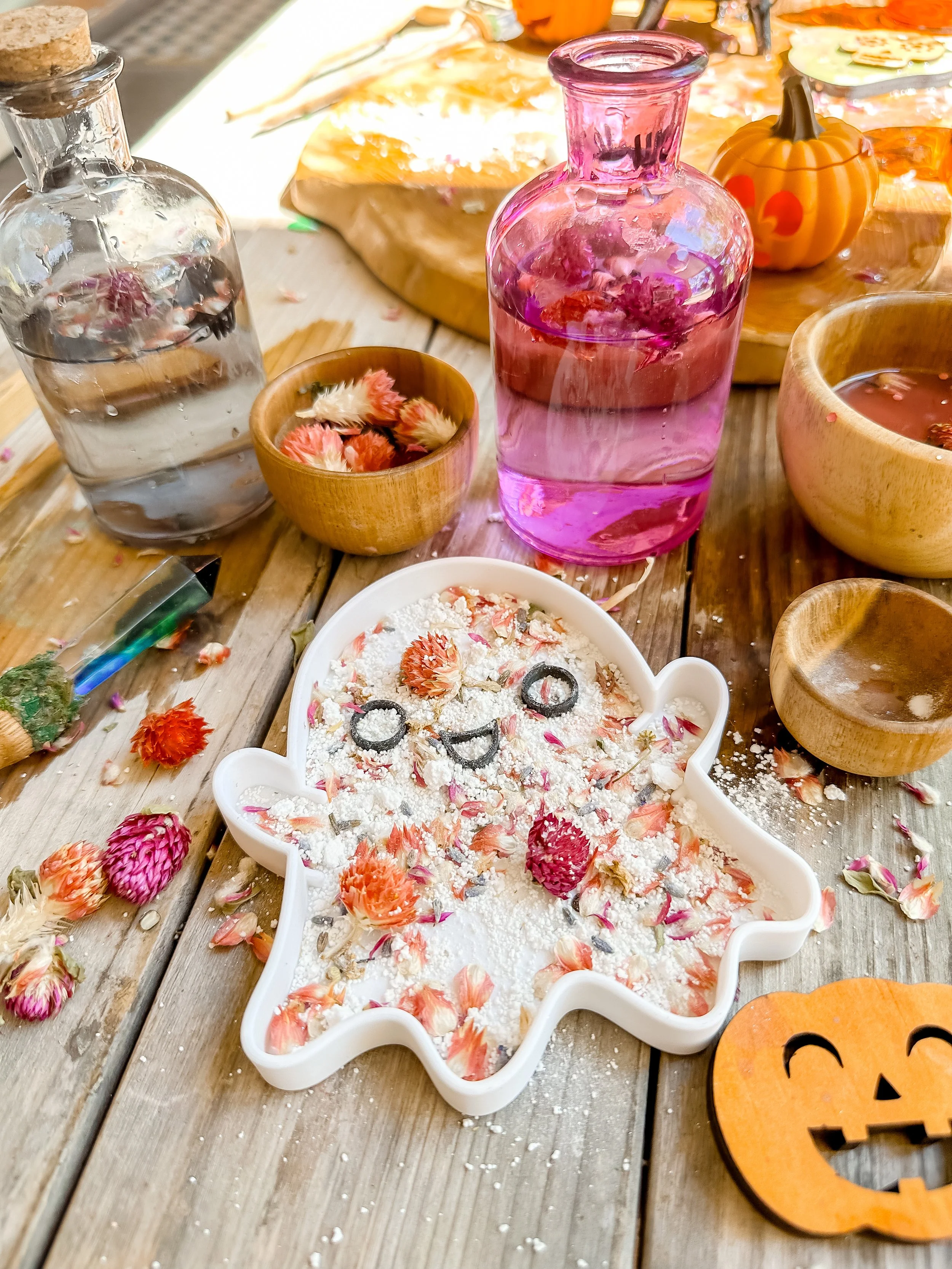 Children exploring Halloween sensory play with pumpkins, scoops and sensory base materials