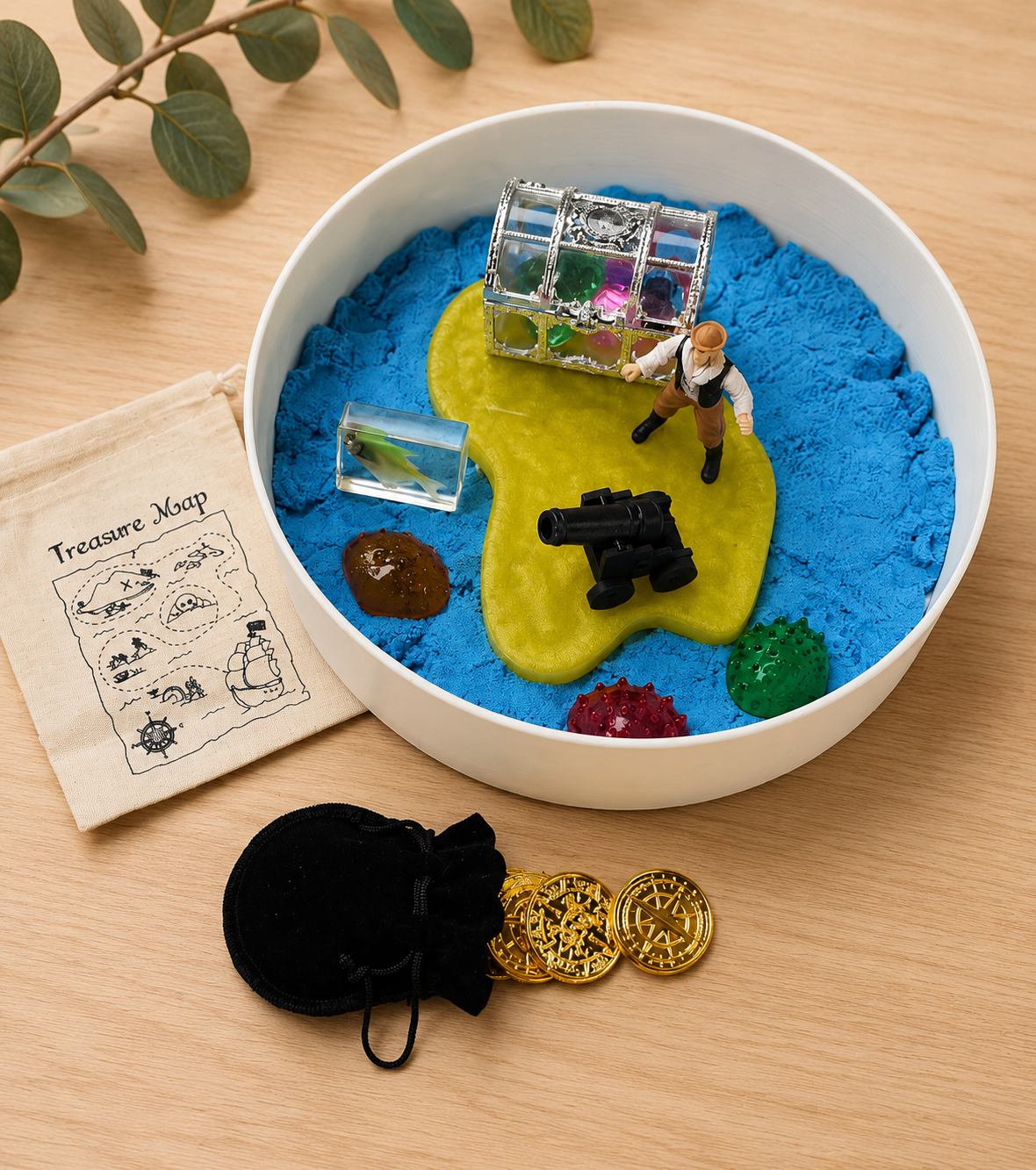 Pirate sensory play setup with magic sand, treasure chest, pirate and island