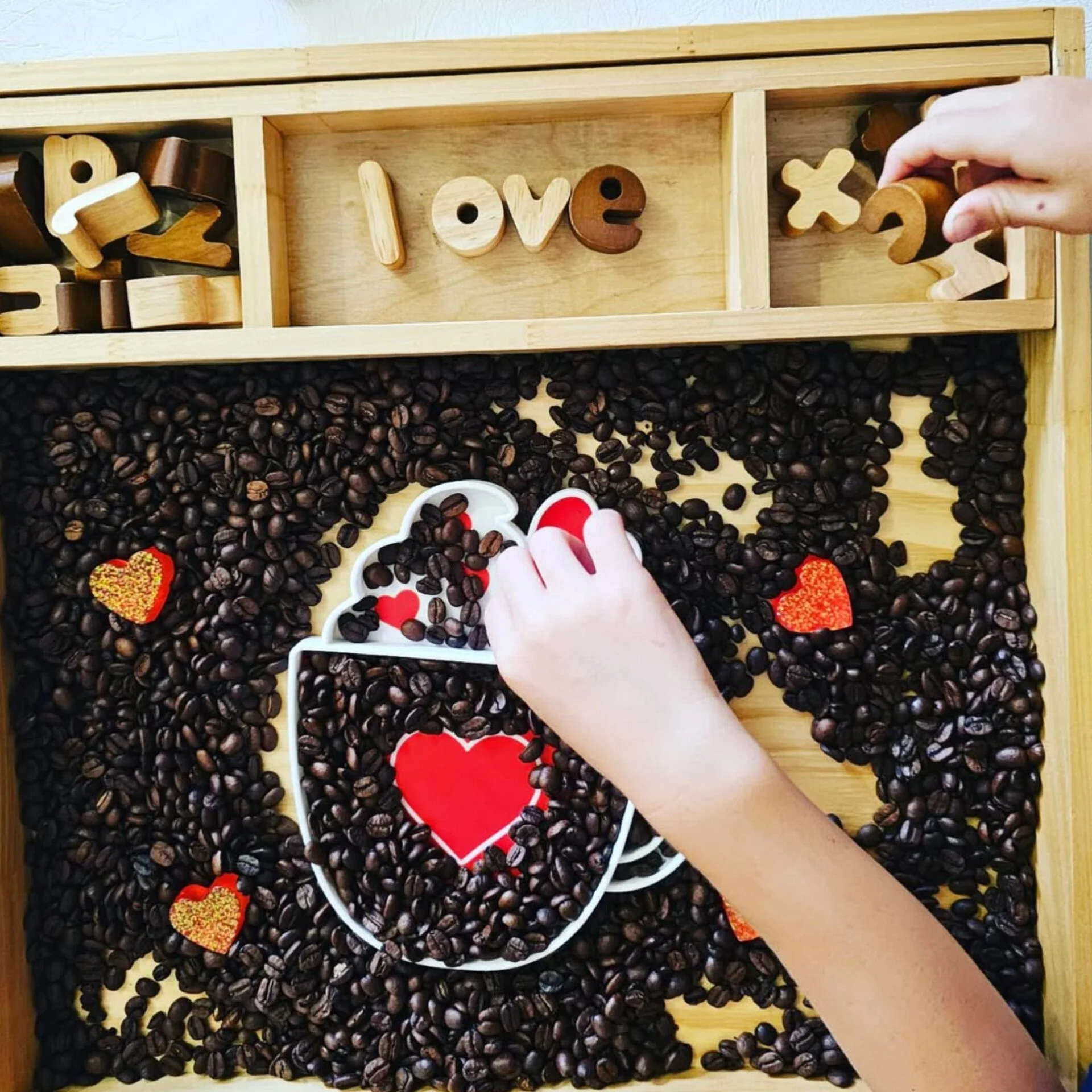 Red love mug sensory tray used for Valentine’s themed potion play and emotional regulation activities