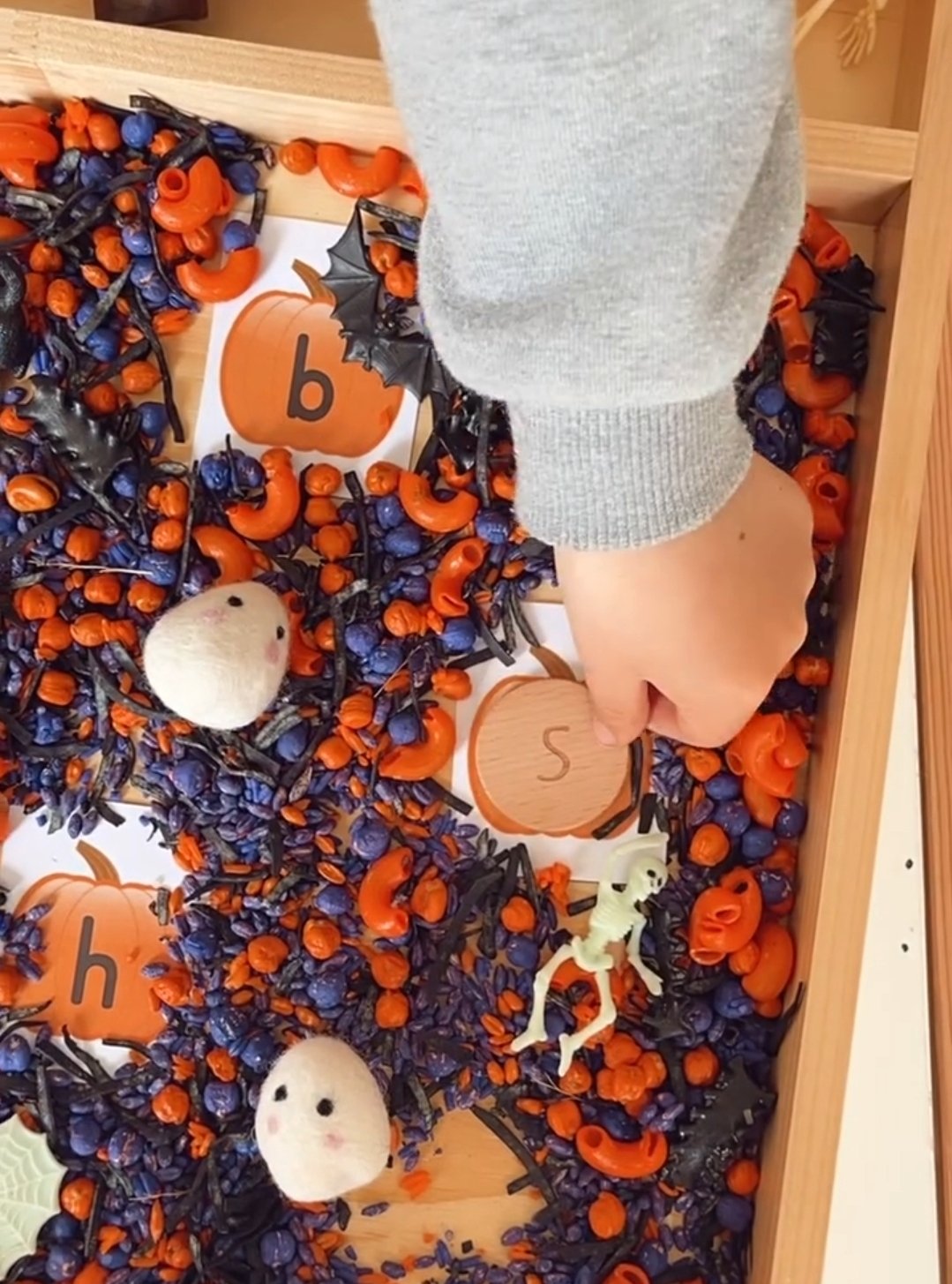 Halloween sensory tray filled with colourful sensory bases, loose parts and themed play resources