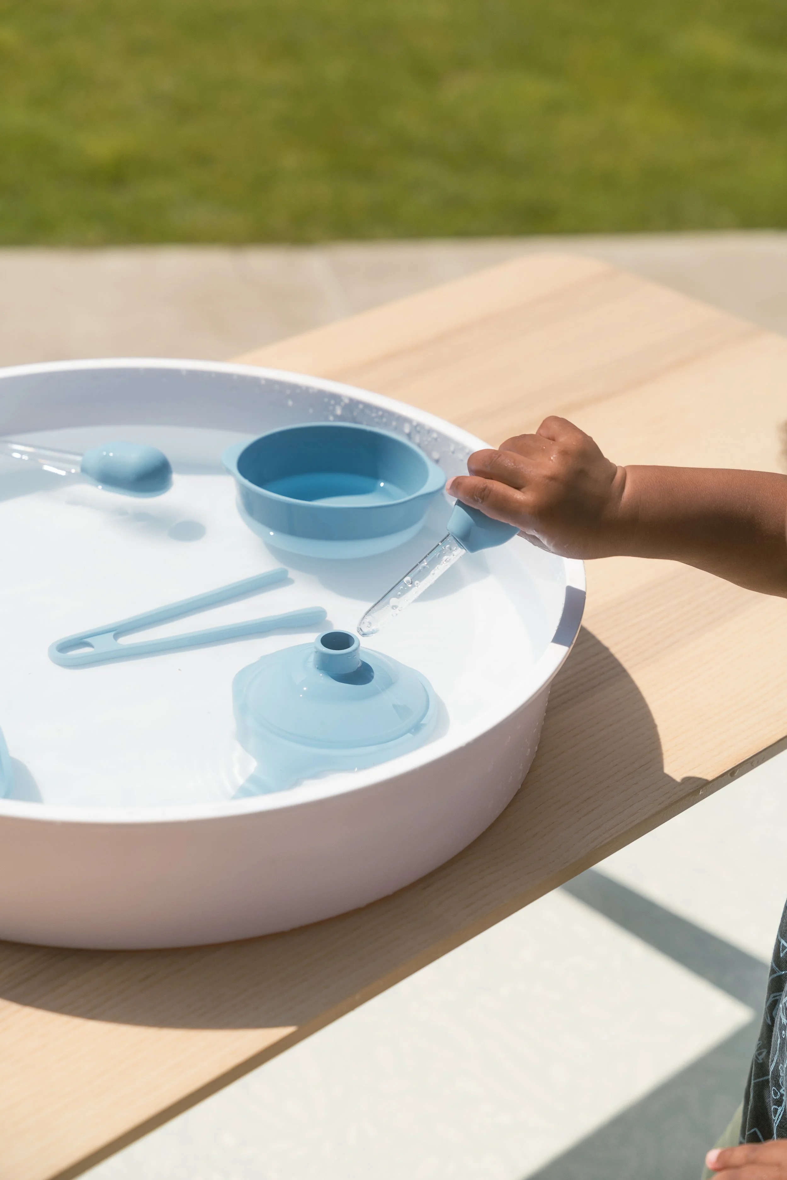 Child using sensory play tongs and tools for fine motor play (Copy)