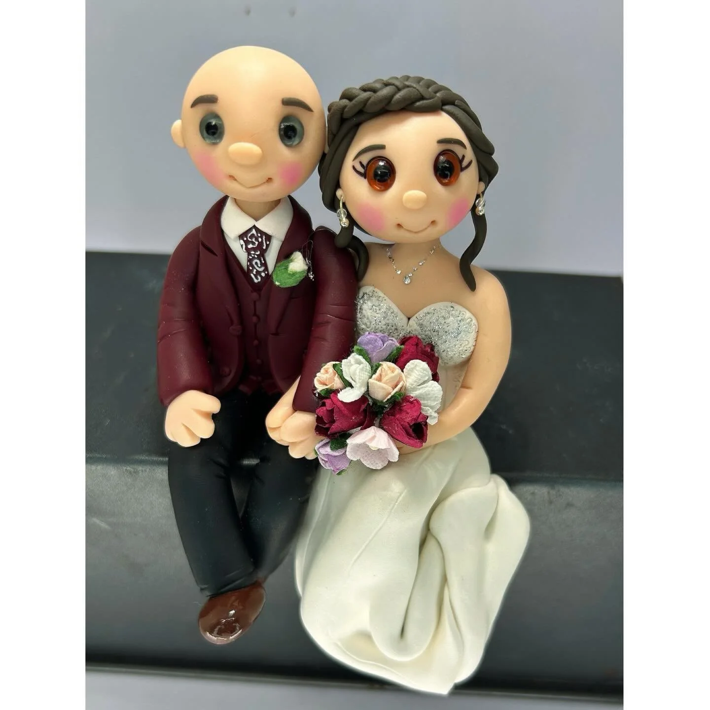 This Bride and Groom Wedding Cake Topper will sit on the edge of the wedding cake. 
Personalised Wedding Cake Toppers, made to order, lifelong keepsakes.
Message me for a quote.
or email me tinylovecaketoppers@gmail.com

Website https://www.tinylove-