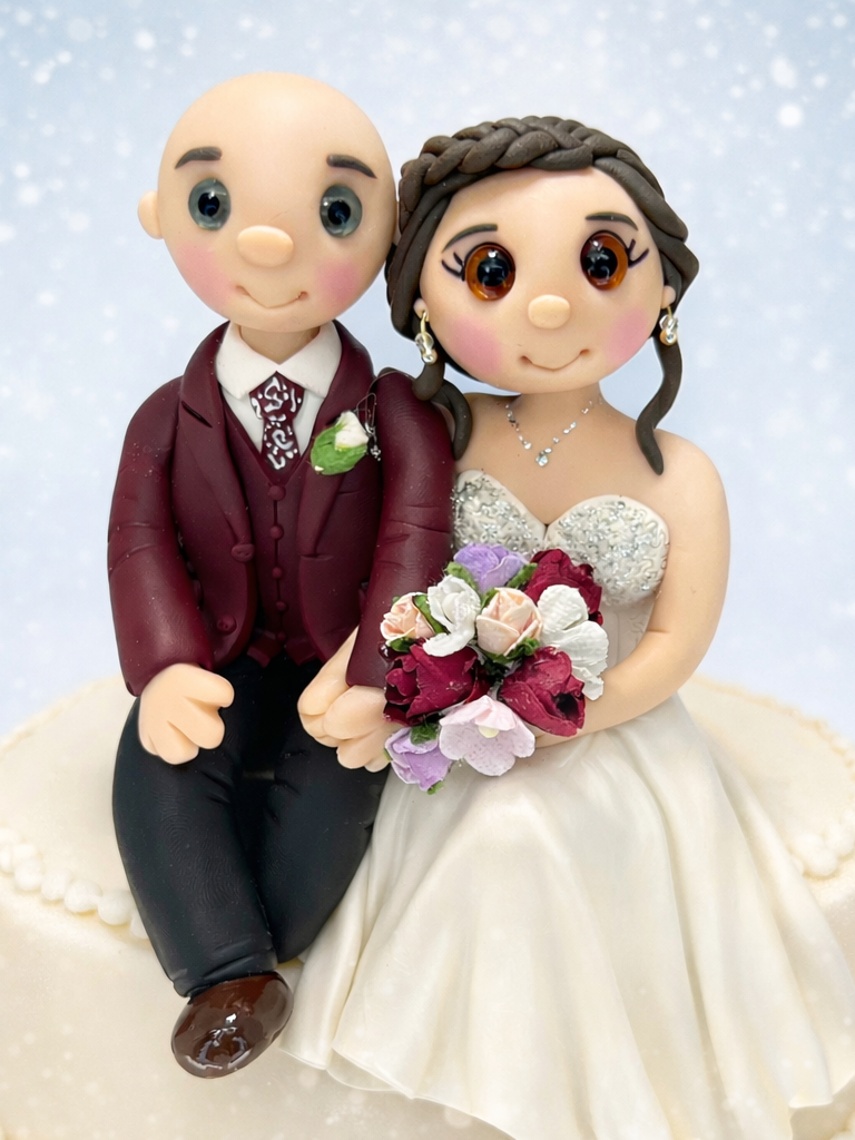 Personalised bride and groom wedding cake topper sitting on the edge of the cake.