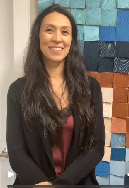 woman in black sweater with long straight brown hair