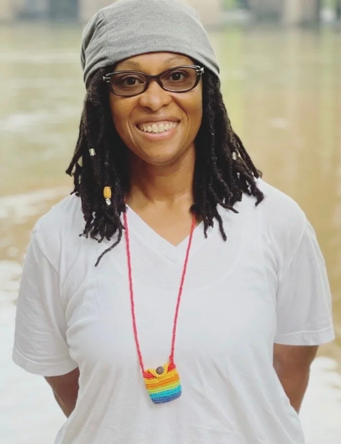 toni with white t-shirt, rainbow pouch, beanie and glasses