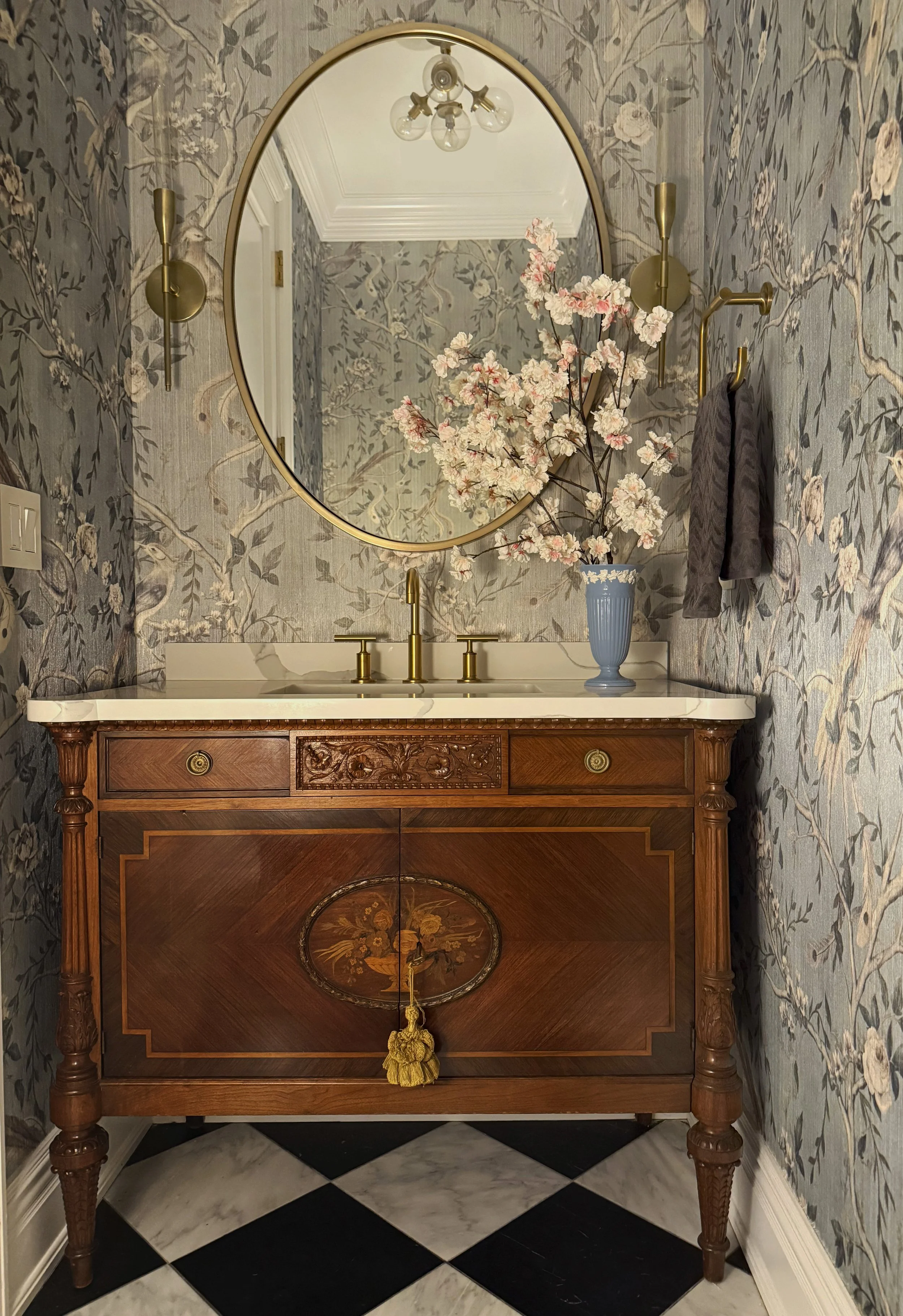 Luxury powder room with antique vanity chest and floral wallpaper 