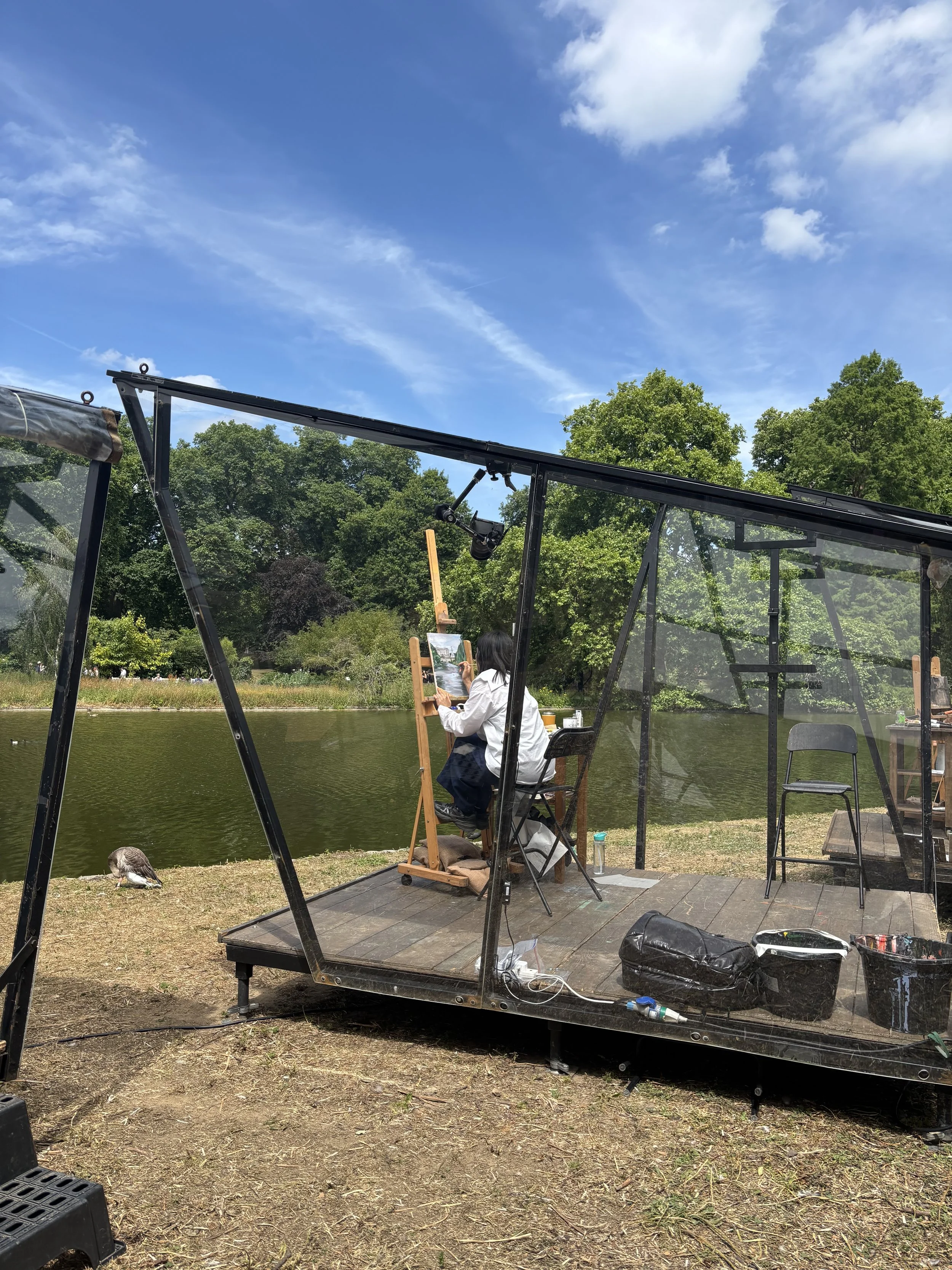 Alice Kwan working inside the iconic artist pod by the lake at St James's Park during the landscape painting competition.