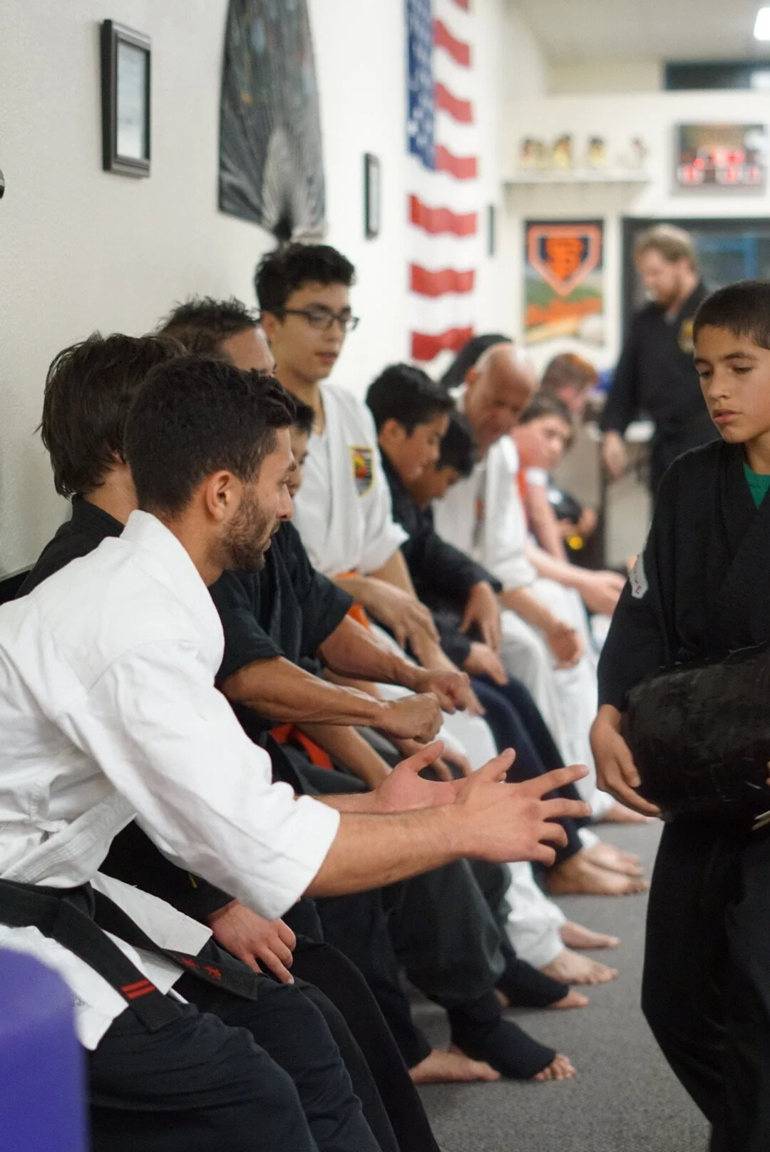 United Studios of Self Defense karate school in Belmont interior picture showing kids, teens, and adult karate students waiting for class to begin