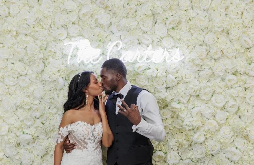 Ivory and white wall with a custom sign and THE cutest couple!