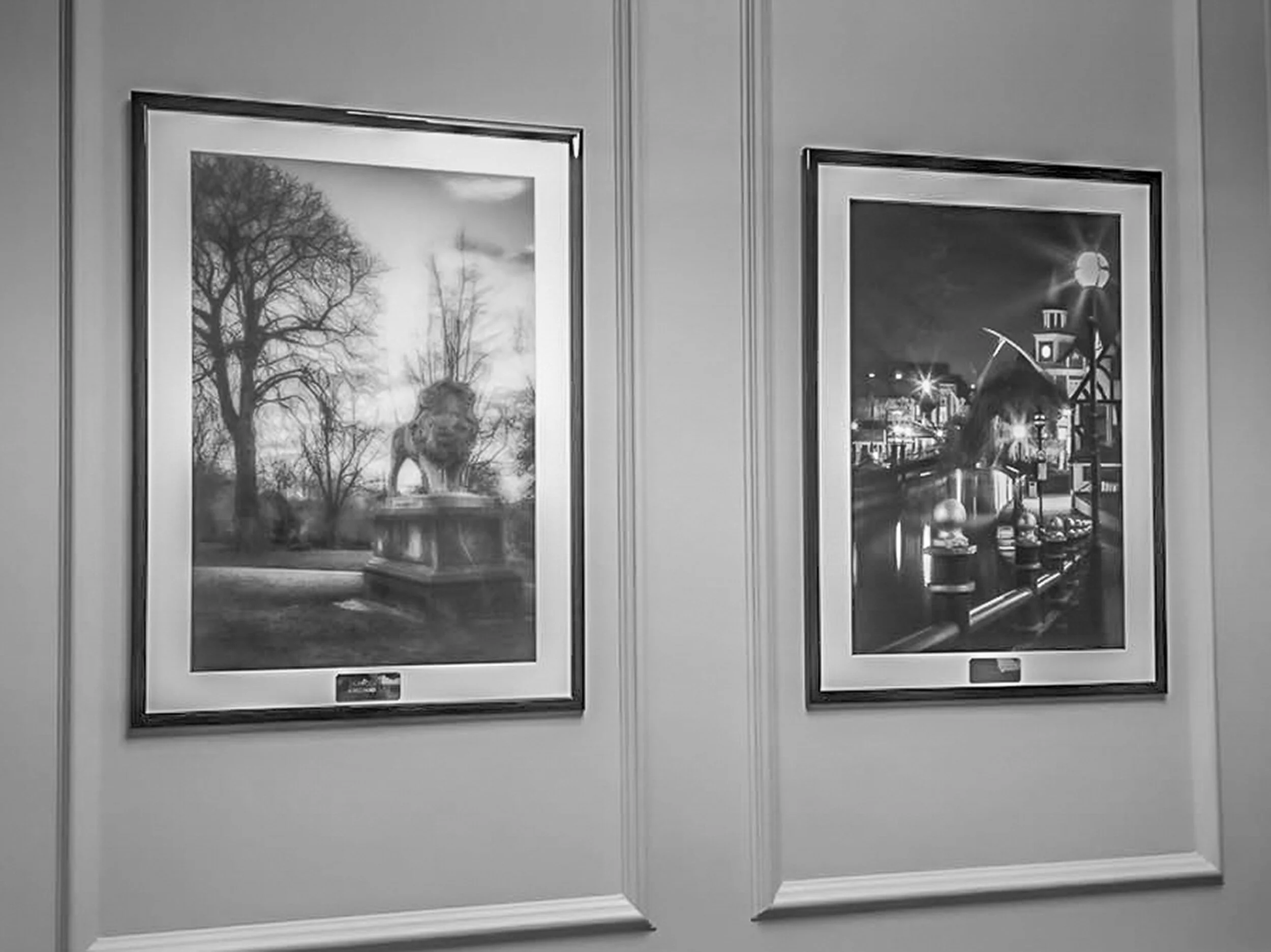 Two framed black and white landscape photos hanging on a wall.
