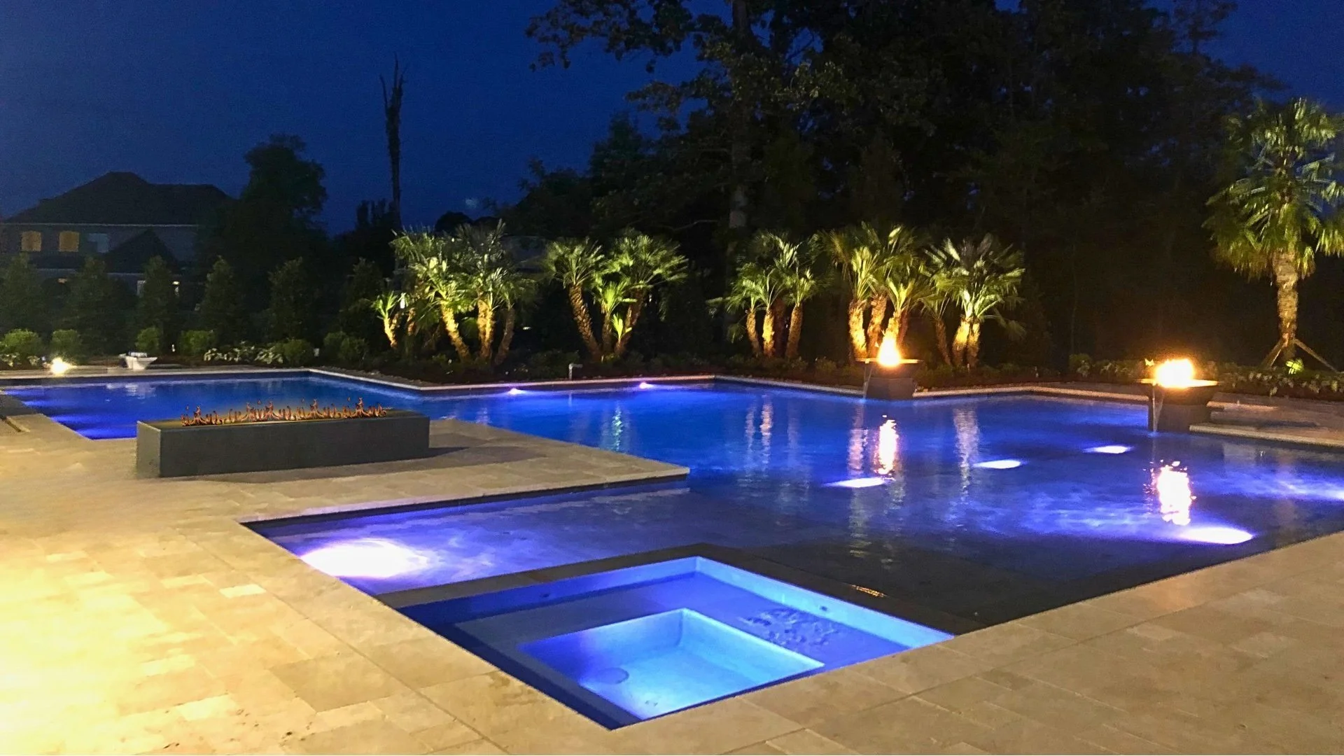 POOL DESIGNED, ENGINEERED AND BUILT BY WATERSCAPES OF SHREVEPORT.  NIGHT PHOTO OF POOL, SPA AND FIRE FEATURES.
