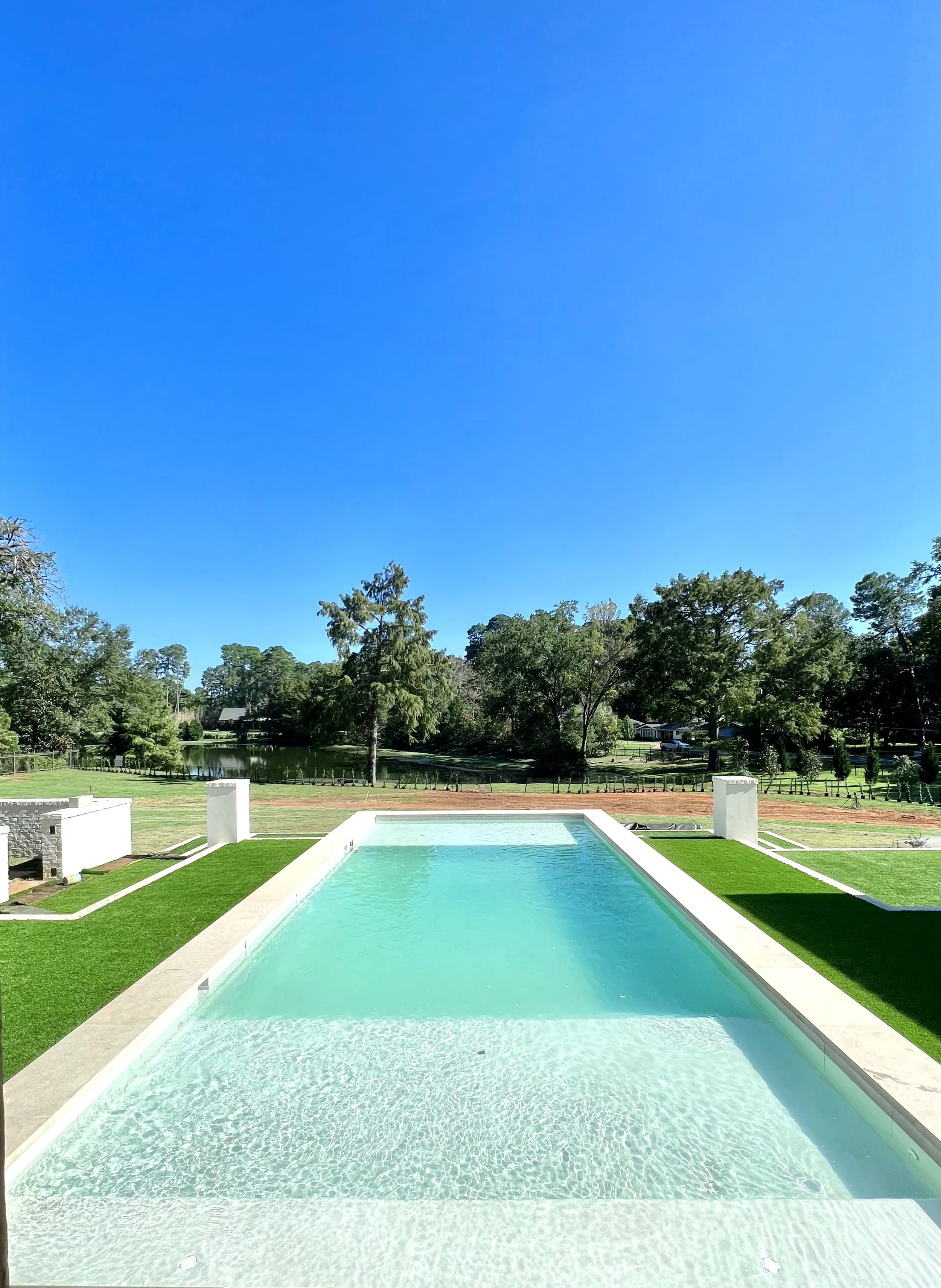 The custom swimming pool engineered and constructed by Waterscapes NWLA sits behind a French Provincial Style residence designed by Farmer Payne Architects and built by Wesley Thomas Construction.  The swimming pool features a multi-tiered terrace an