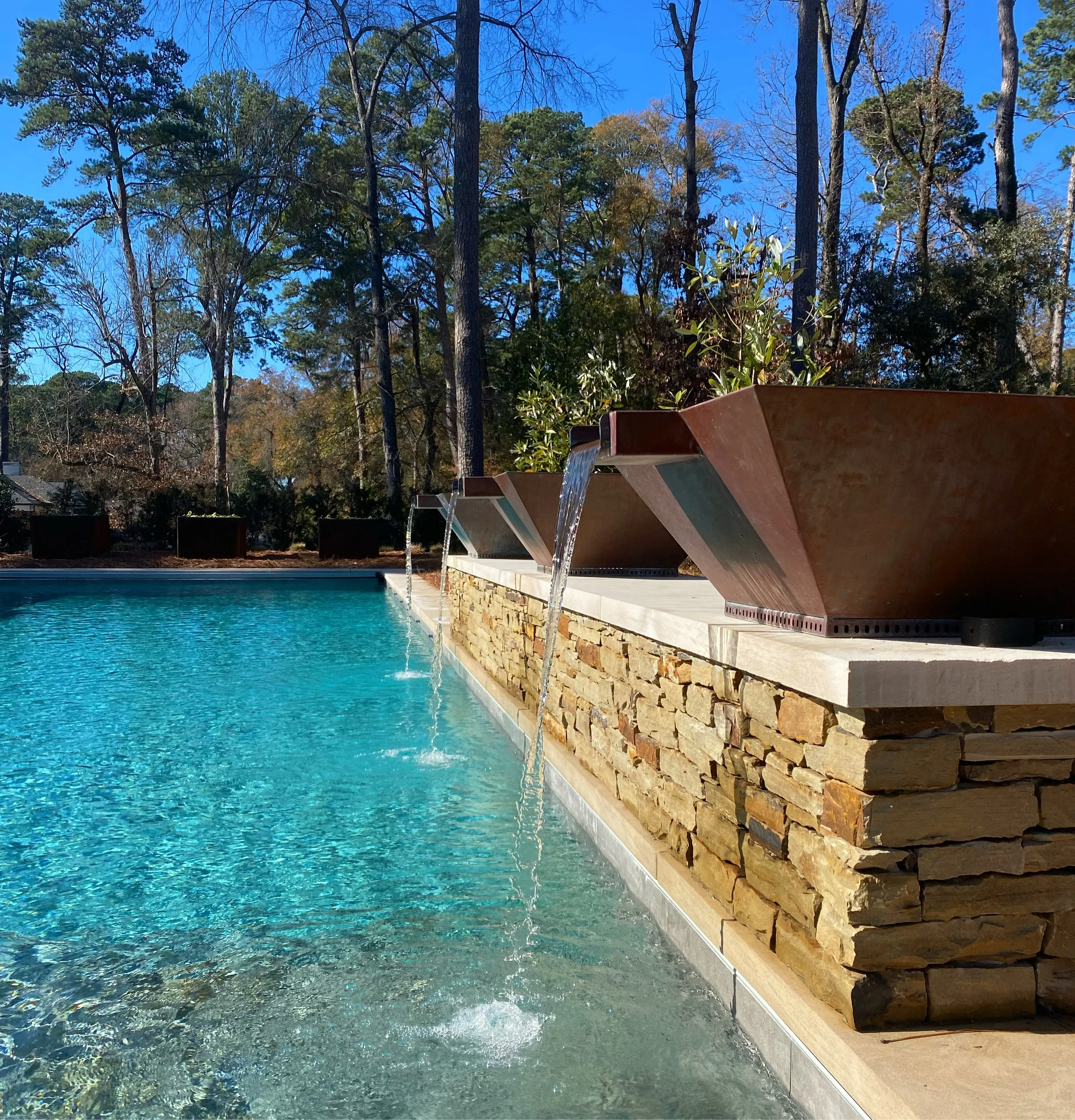 Coppers Bowl Fountains mounted on limestone coping over stacked rock