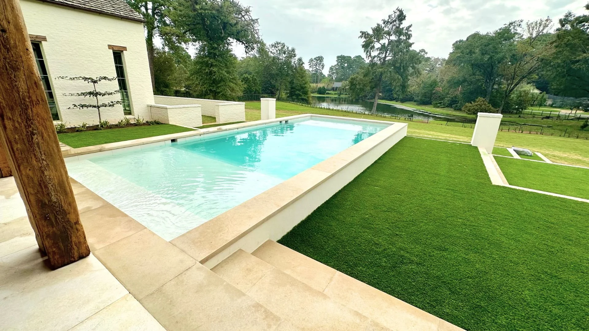 The custom swimming pool engineered and constructed by Waterscapes NWLA sits behind a French Provincial Style residence designed by Farmer Payne Architects and built by Wesley Thomas Construction.  The swimming pool features a multi-tiered terrace an