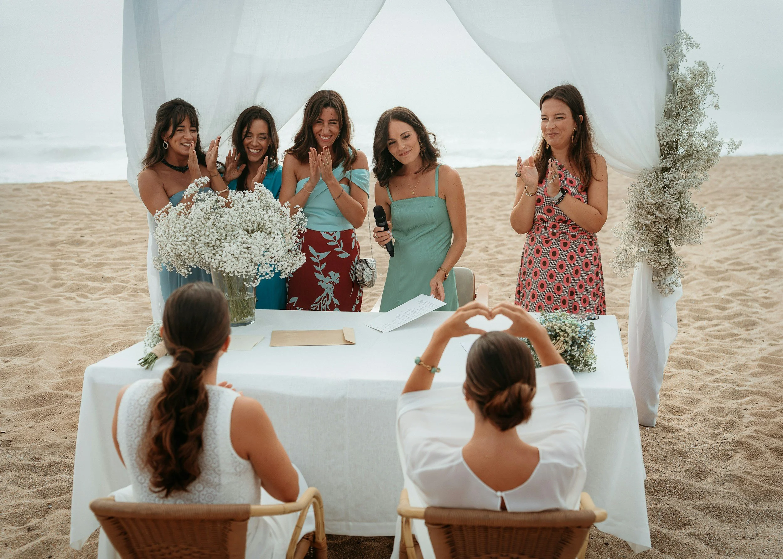 Happy women around table on the beach