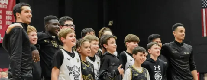 Group of young boys and two adults posing for a photo at a sports event or ceremony.