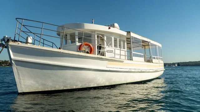 A white boat on the water under a clear blue sky.