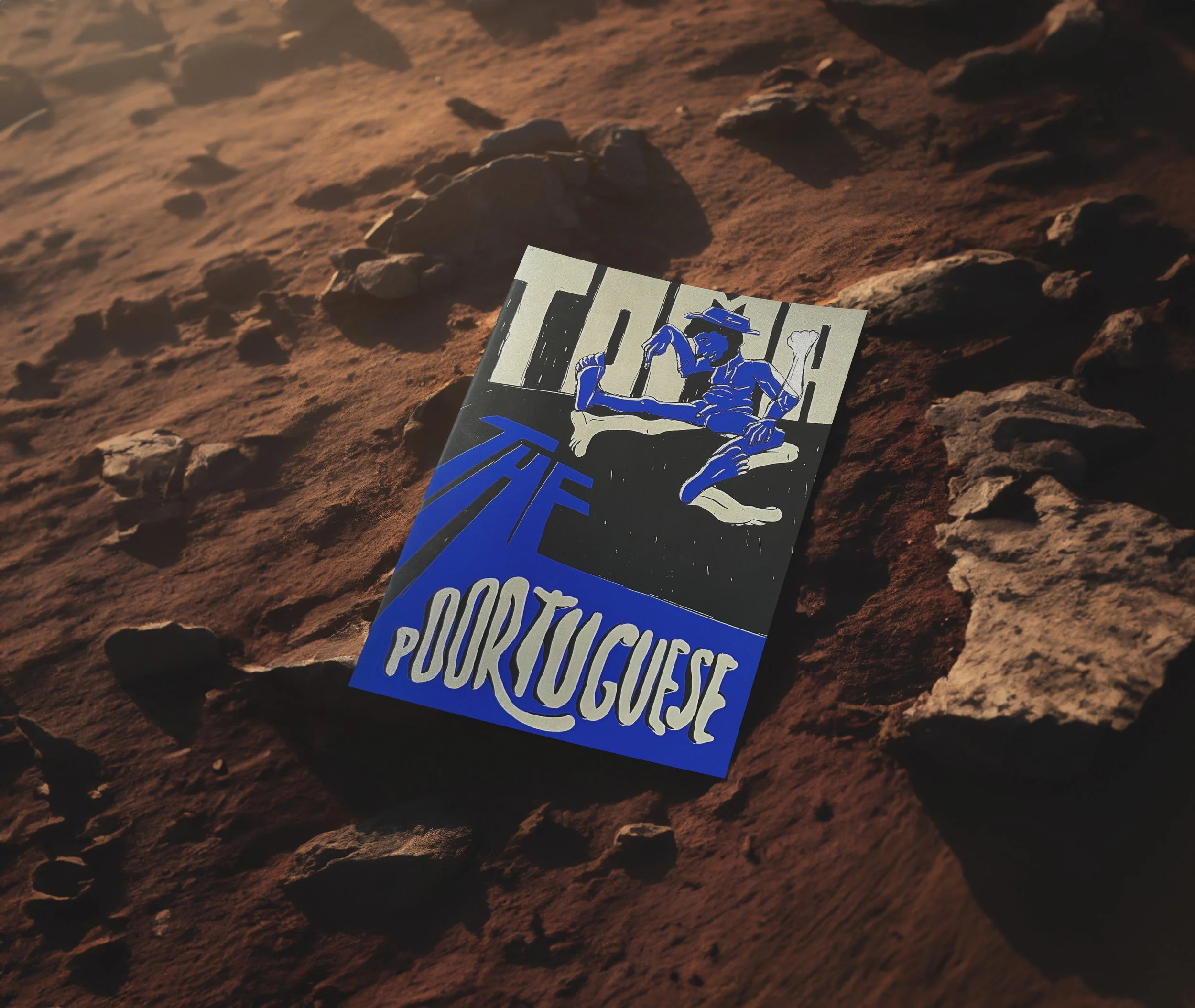 A poster lying on reddish-brown rocky terrain. The poster features a black and white illustration of a woman with short hair and a hat, sitting confidently with one arm resting on her knee and the other on her head. The background of the poster is black with blue and white text.