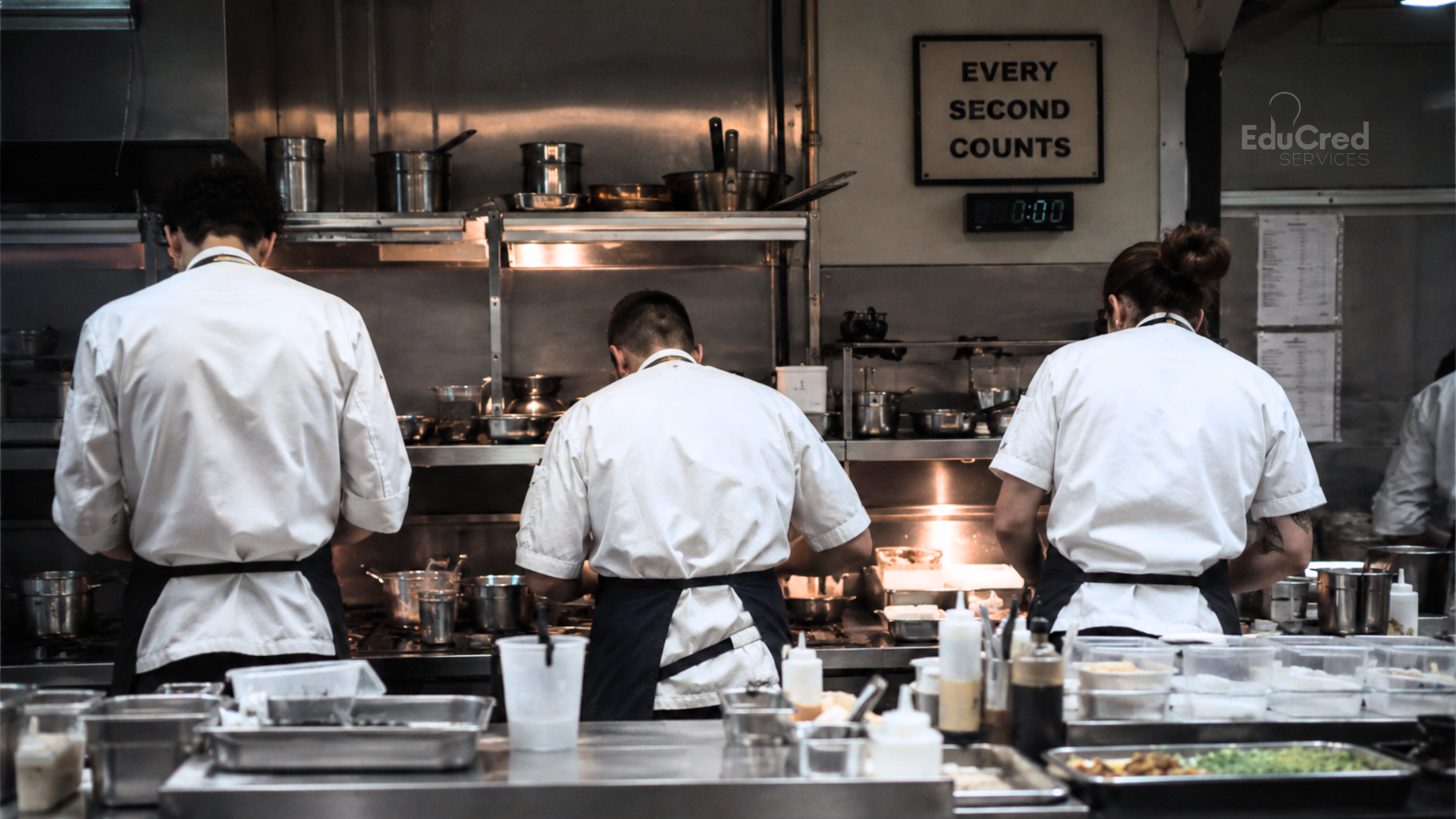 A team of chefs work in a professional kitchen. A sign says Every Second Counts