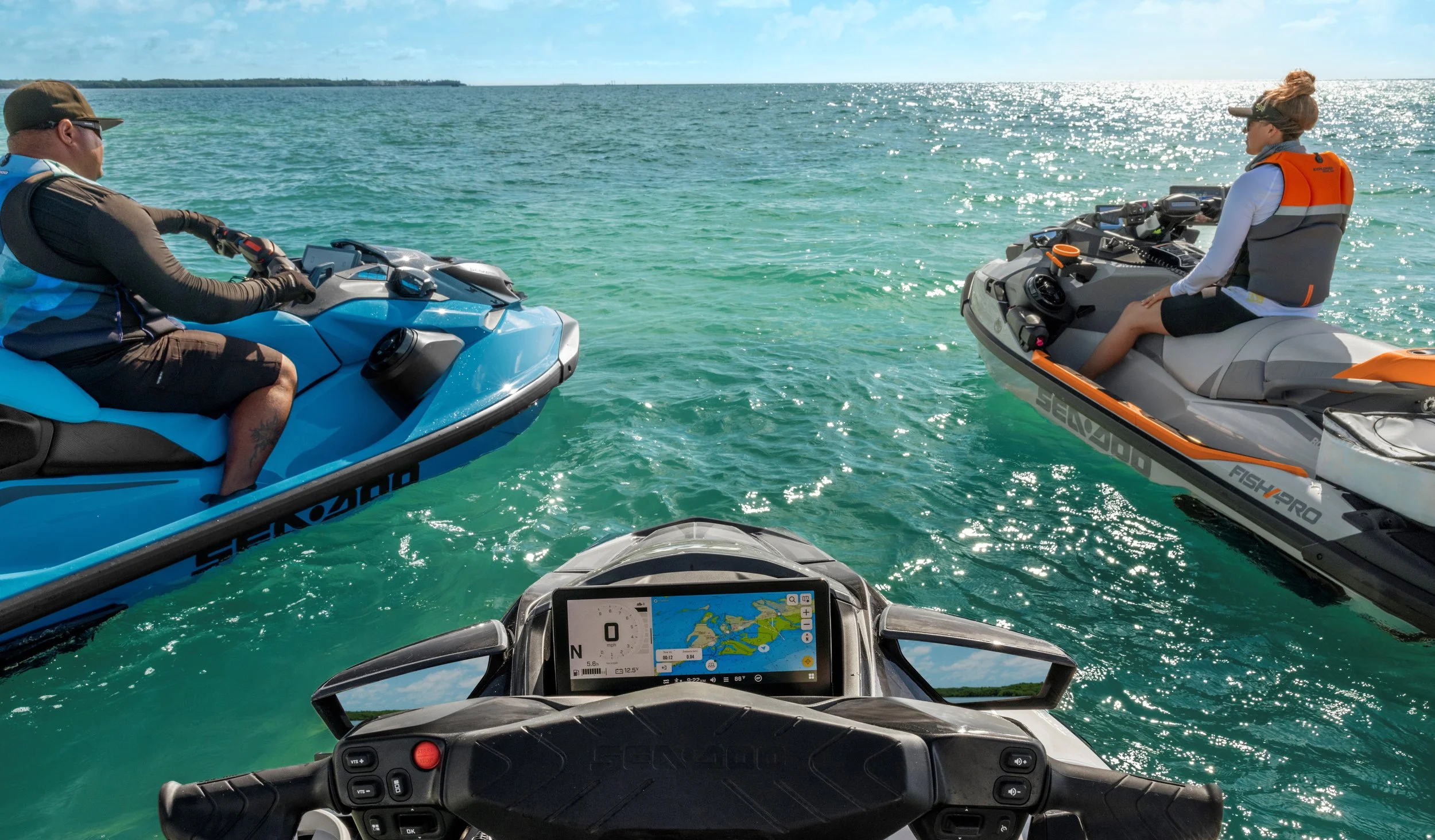 Three people on Sea-Doo jet skis in the water, with a GPS navigation screen displaying on one jet ski.
