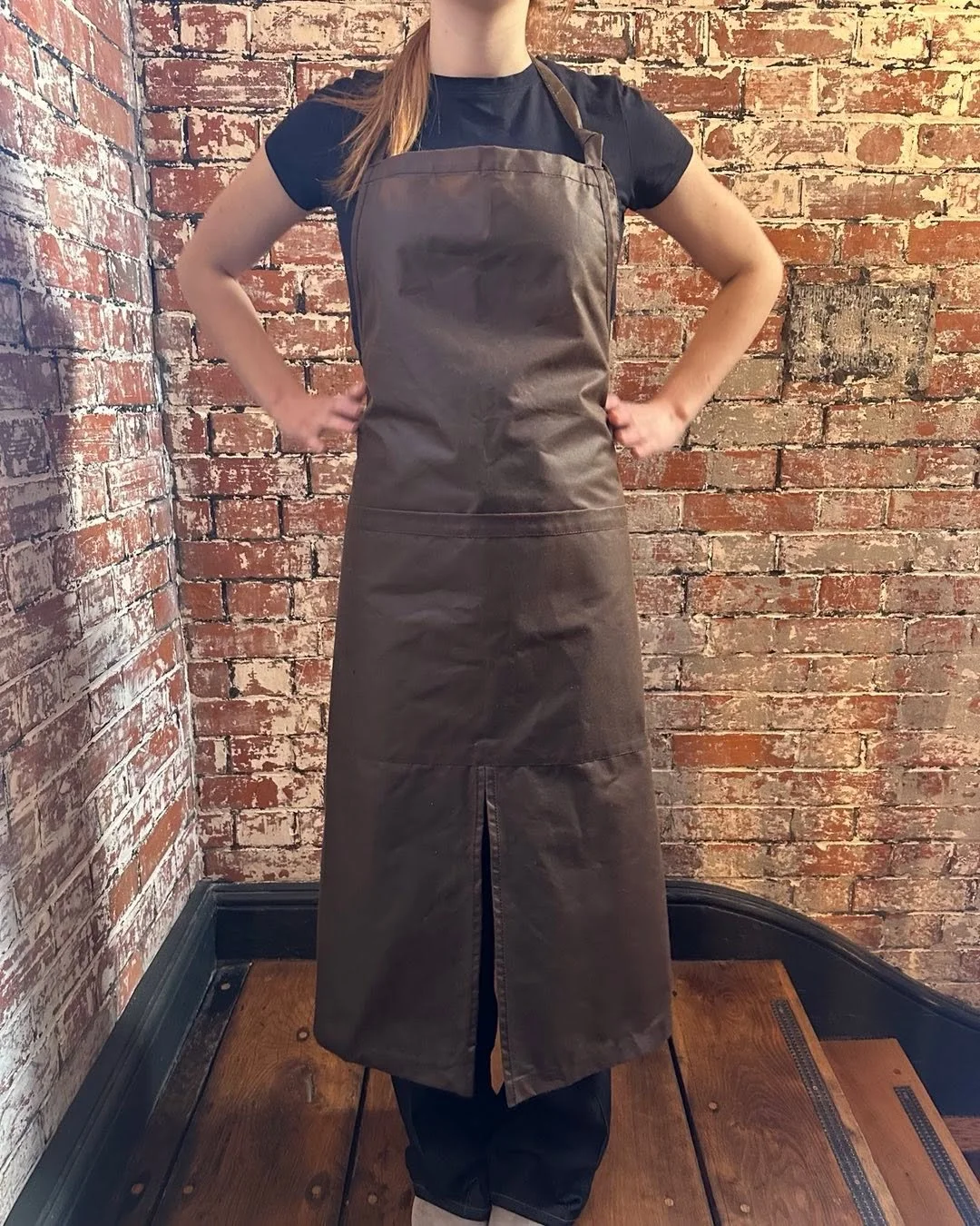 Our Makers apron is handcrafted using British waxed cotton. It&rsquo;s as hard wearing as leather, waterproof, wipe clean and super lightweight.
With an adjustable neck strap and extra long waist straps for tying at the front or back. It has a split 