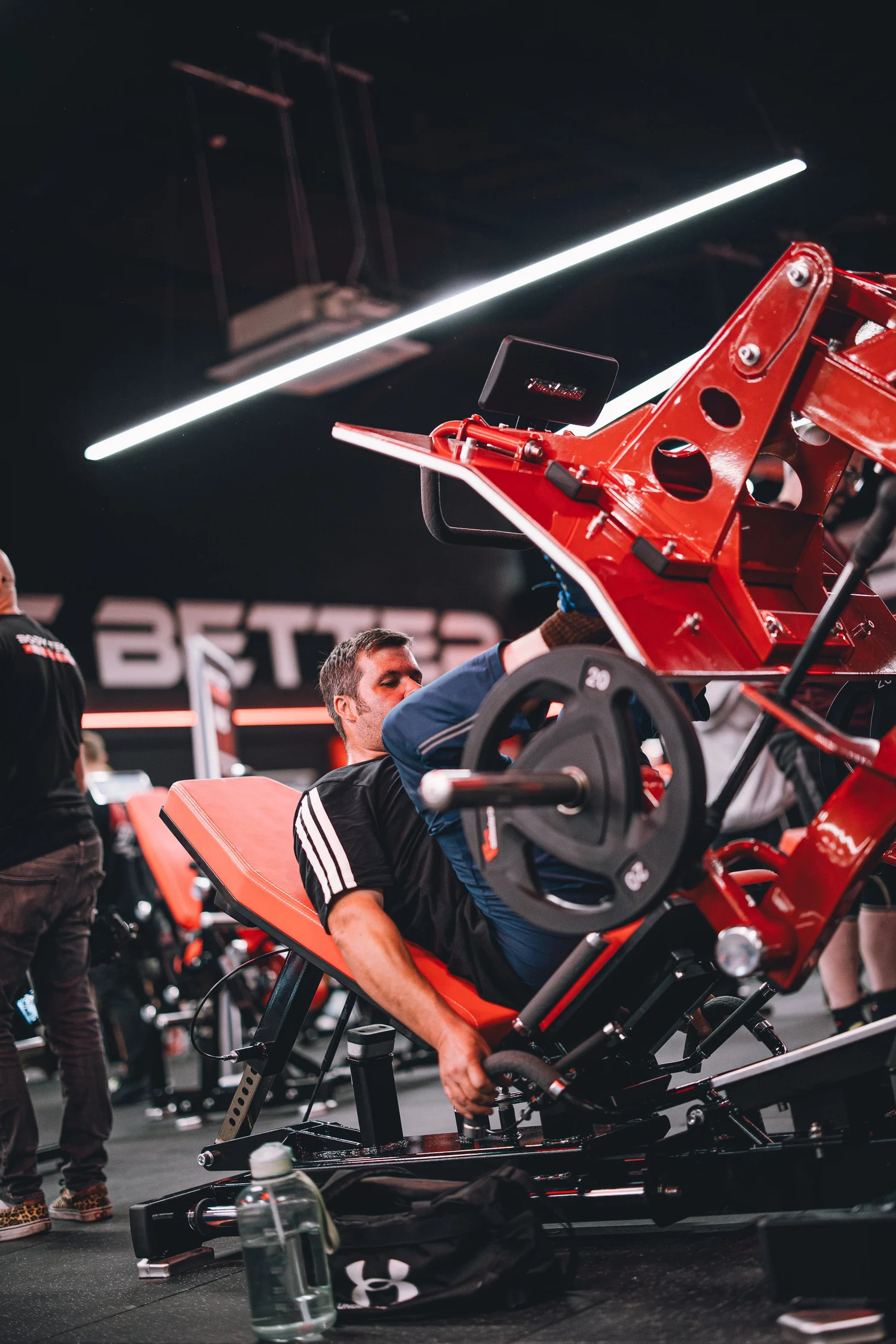 Member using red plate-loaded leg press equipment at Body Tech Wrexham