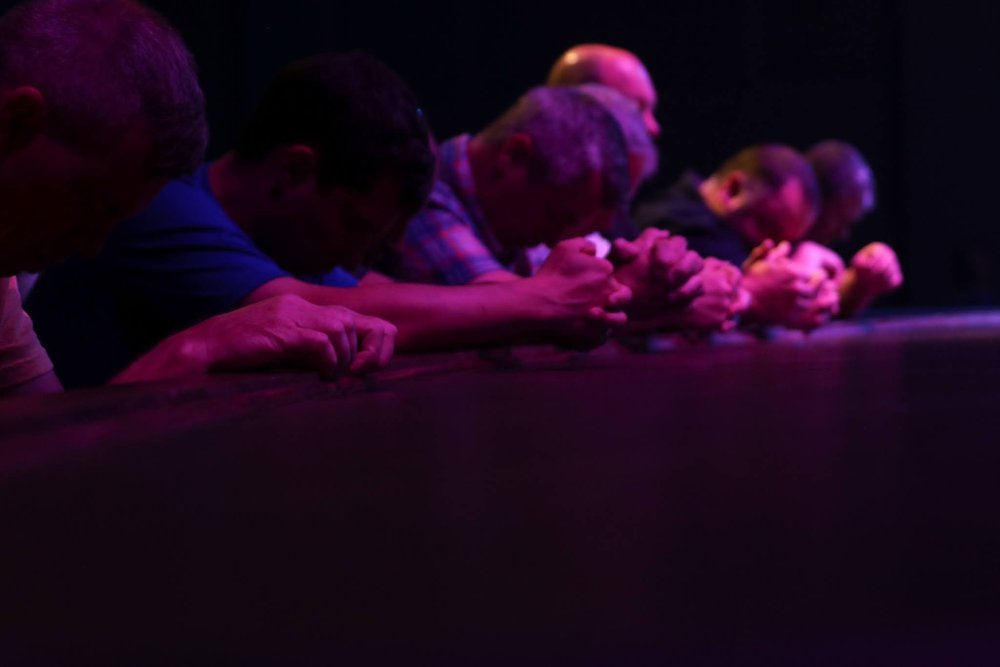Freedom Church Prayer & Care Team members praying together with hands clasped