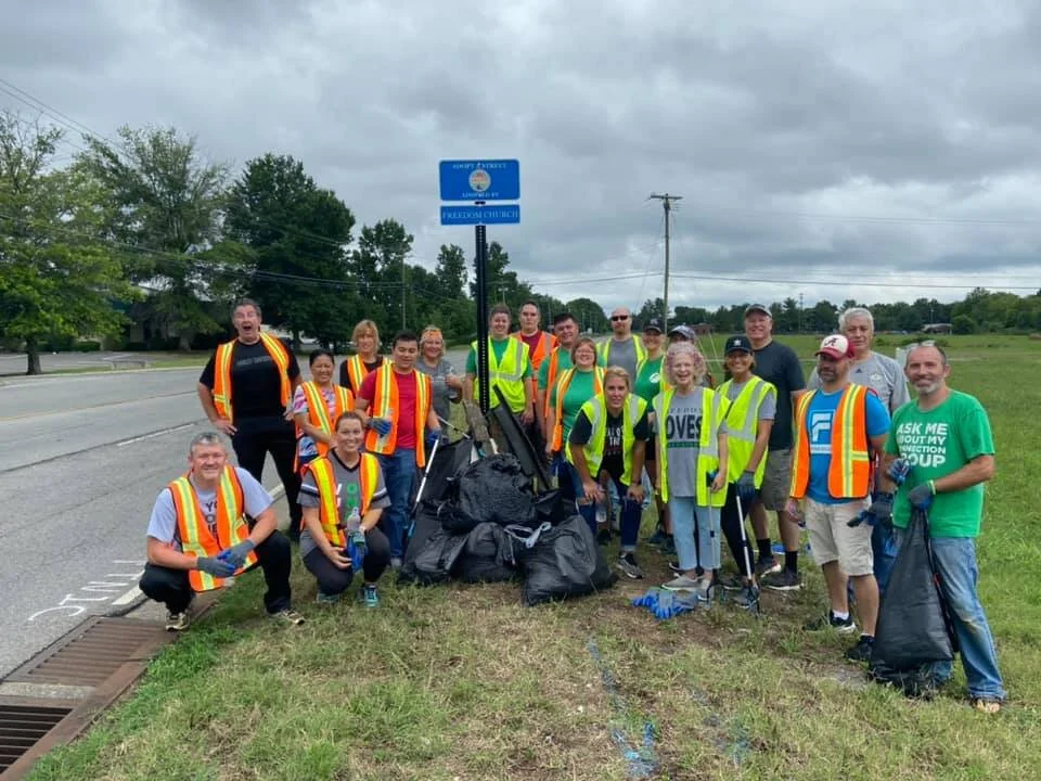 Freedom Church volunteers in safety vests after a community roadside cleanup