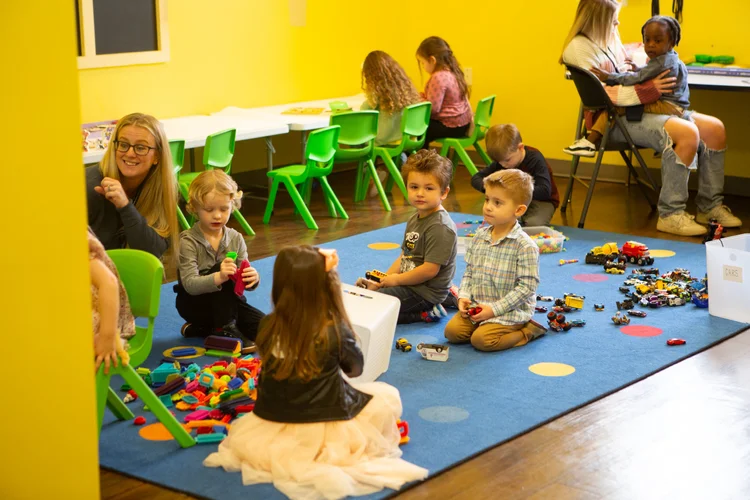Preschoolers playing together on a classroom rug