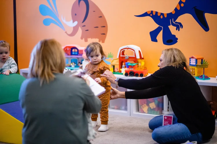 A nursery volunteer playing with a toddler