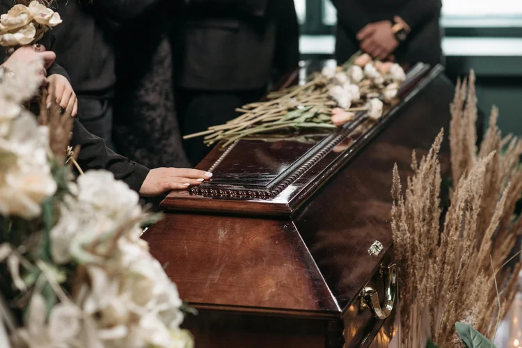 Flowers resting on a casket at a memorial service