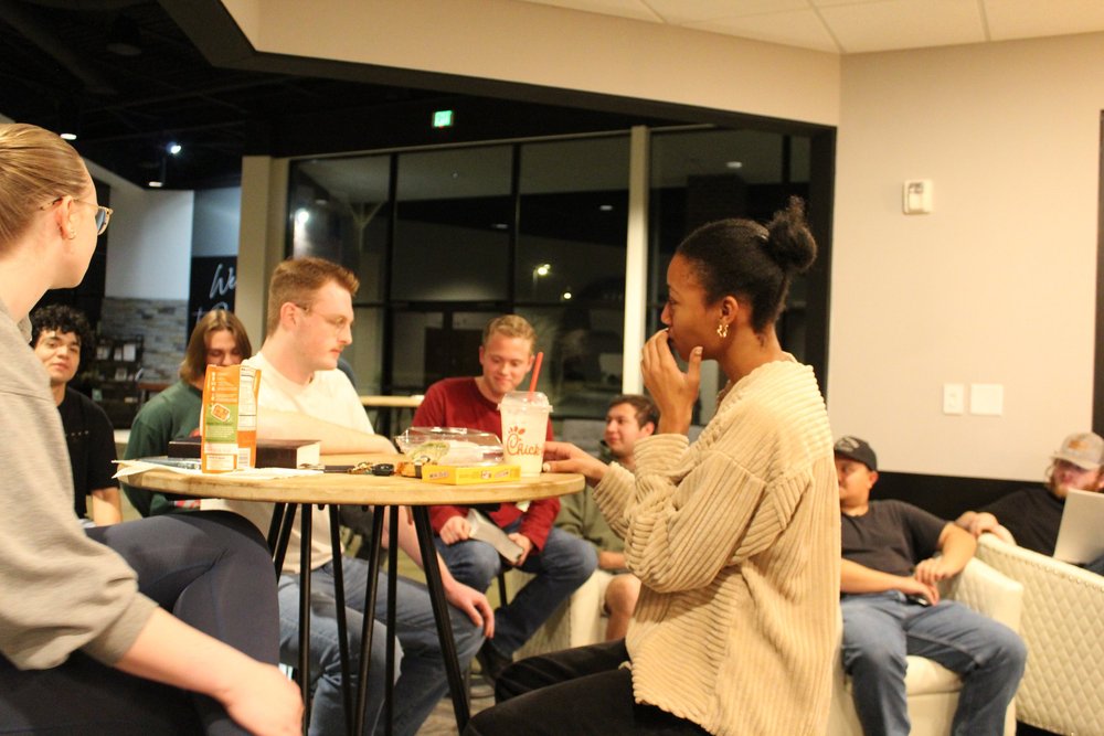 Young adults talking around tables at a Freedom YA night