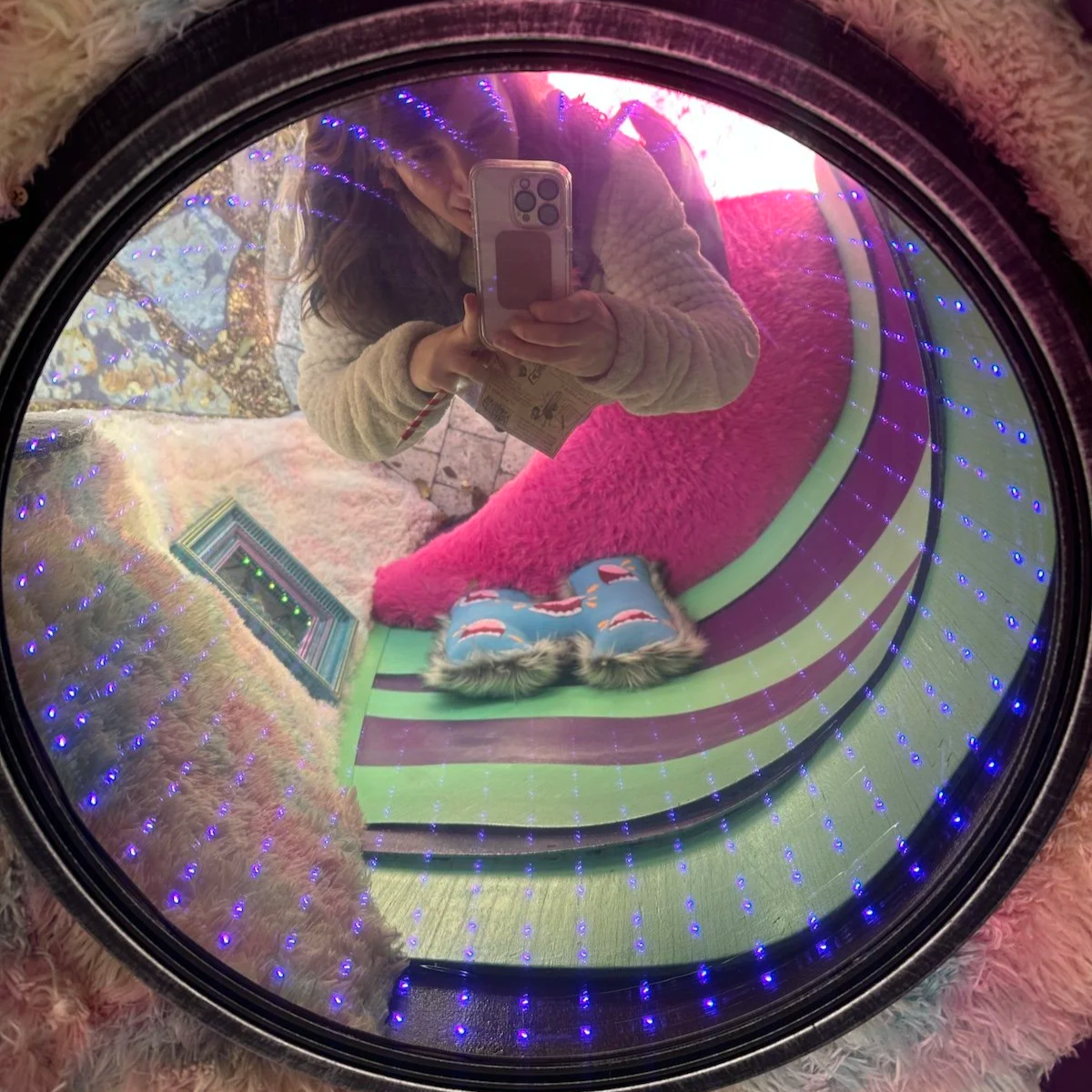 Suzie DeVoe energy healer taking a picture of herself in a mirror at a creative art installation