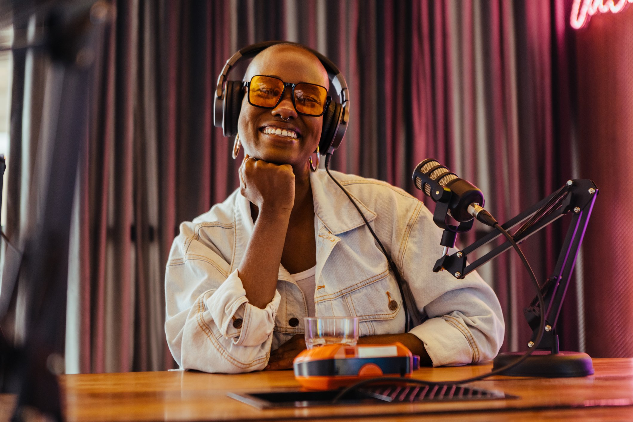 Woman smiling at camera with headphones and a microphone